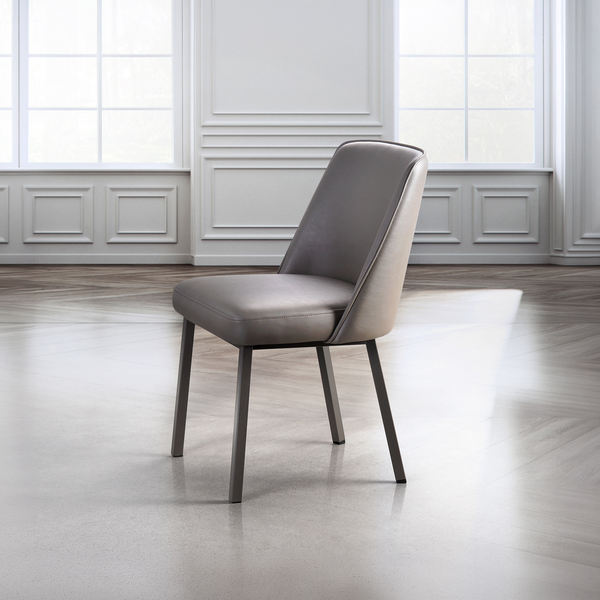 A modern grey upholstered dining chair with dark metal legs sits in a bright room with white wainscoting, large windows, and mixed light-colored flooring.