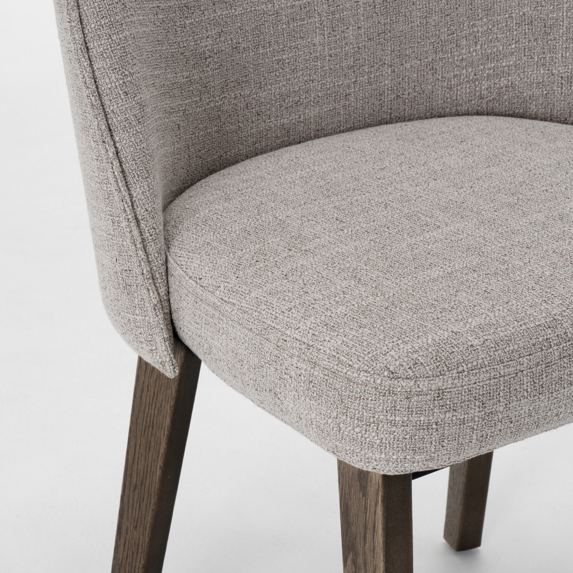 Close-up of a modern light gray textured fabric chair with dark brown wooden legs.