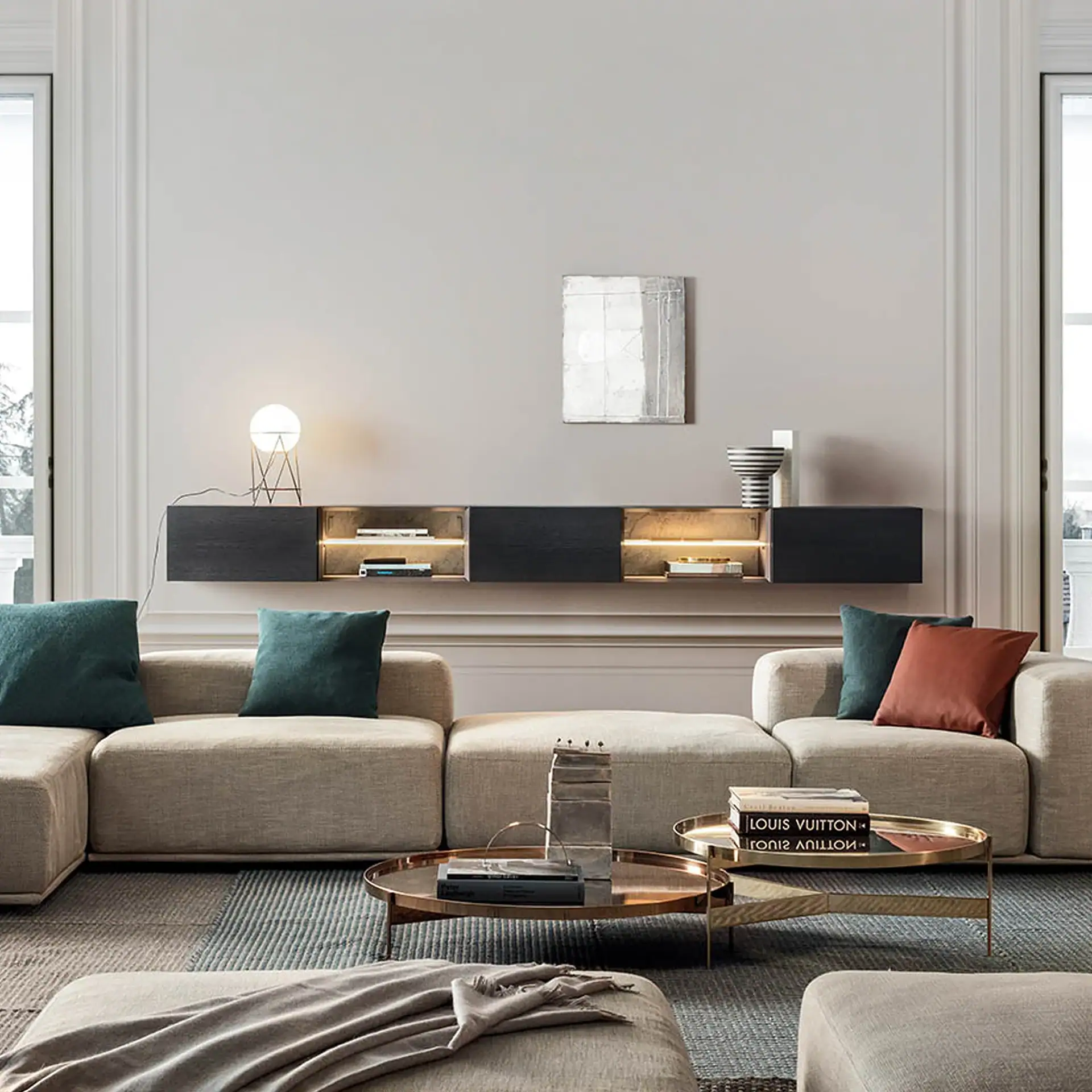 A modern living room with a beige modular sofa, a dark floating media console with illuminated shelves, and two round metallic coffee tables on a patterned rug.