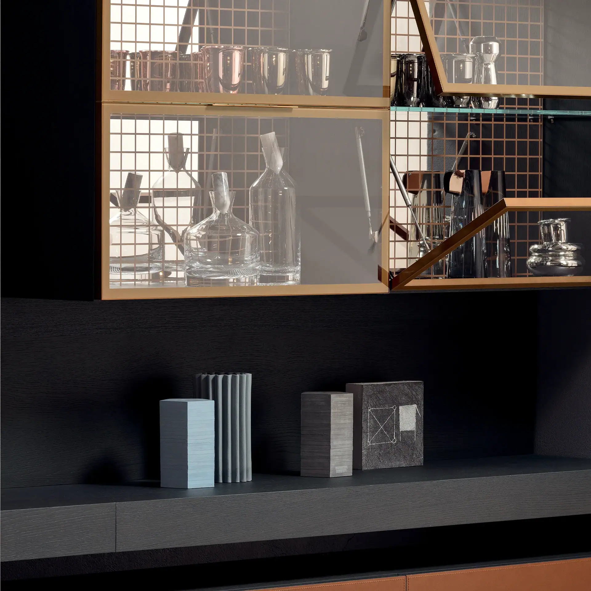 A modern dark wood cabinet featuring glass display units with gold frames and copper grids, filled with glassware, and a lower shelf adorned with four unique decorative blocks.