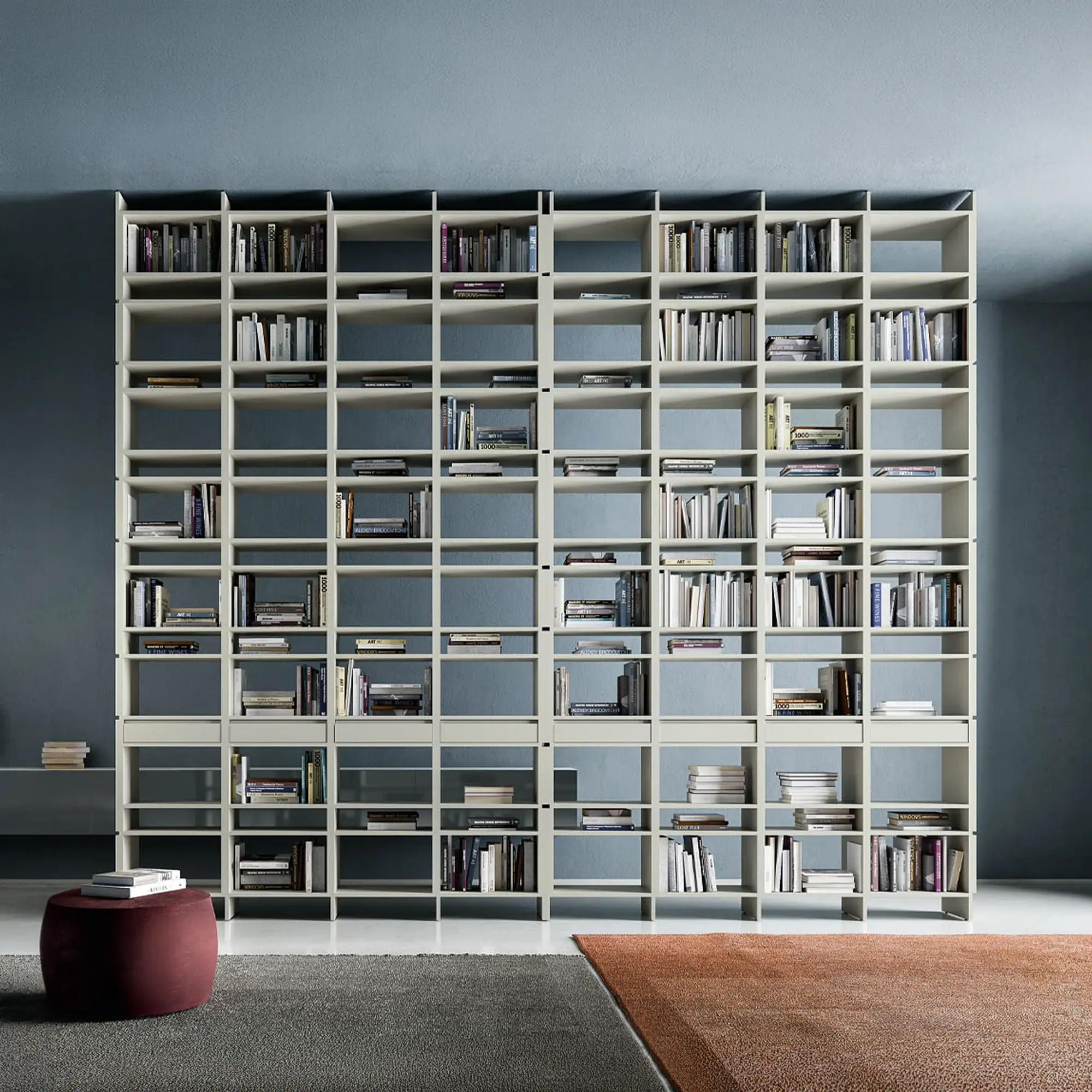 Sklar modular bookshelf wall with numerous compartments filled with books.