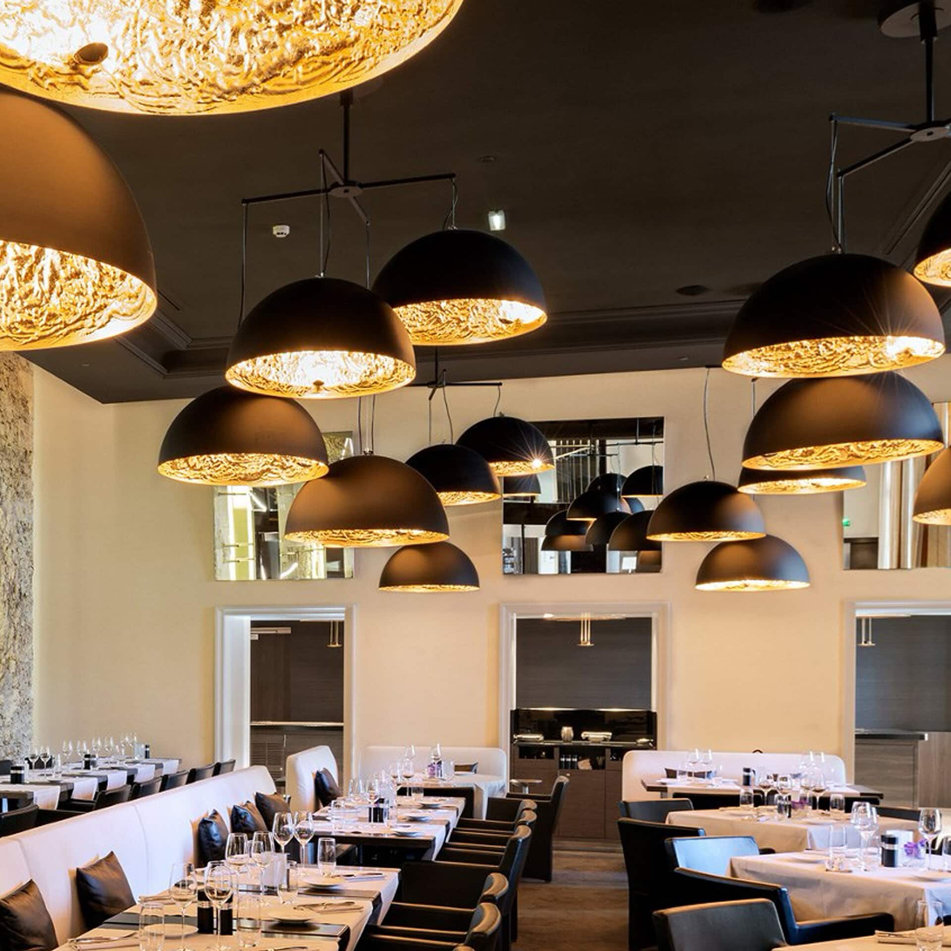 Elegant Stchu-Moon chandelier with black and gold finish in a contemporary dining space.