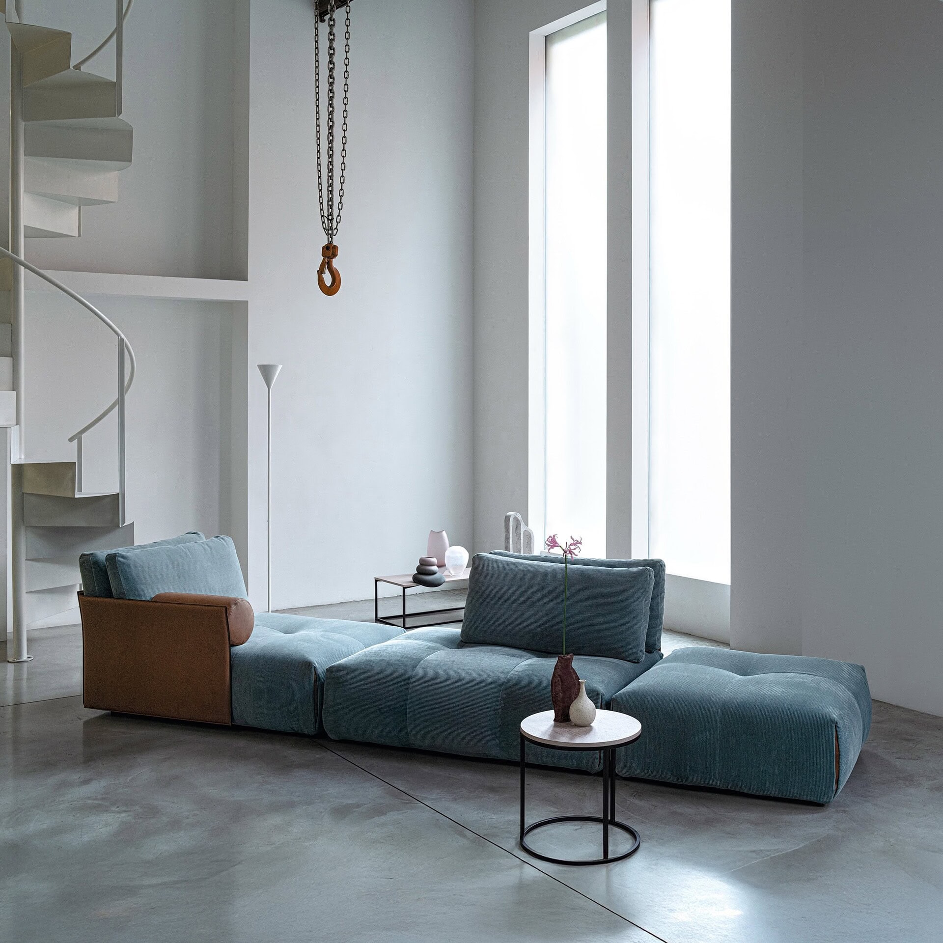 Tab F Sofa in teal upholstery with sleek modern decor.