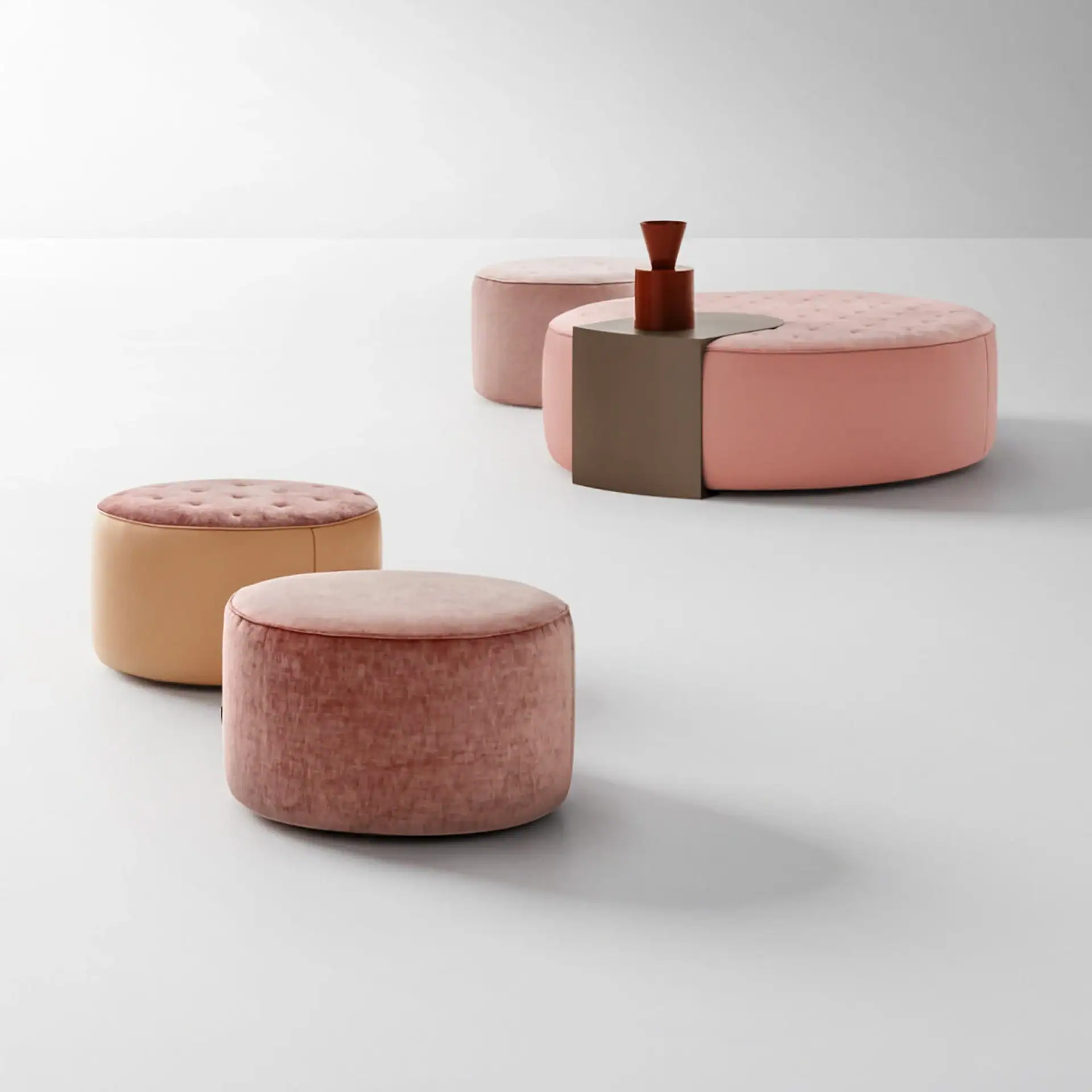 Sklar Furnishings ottomans in pink and peach tones arranged in a minimal showroom.
