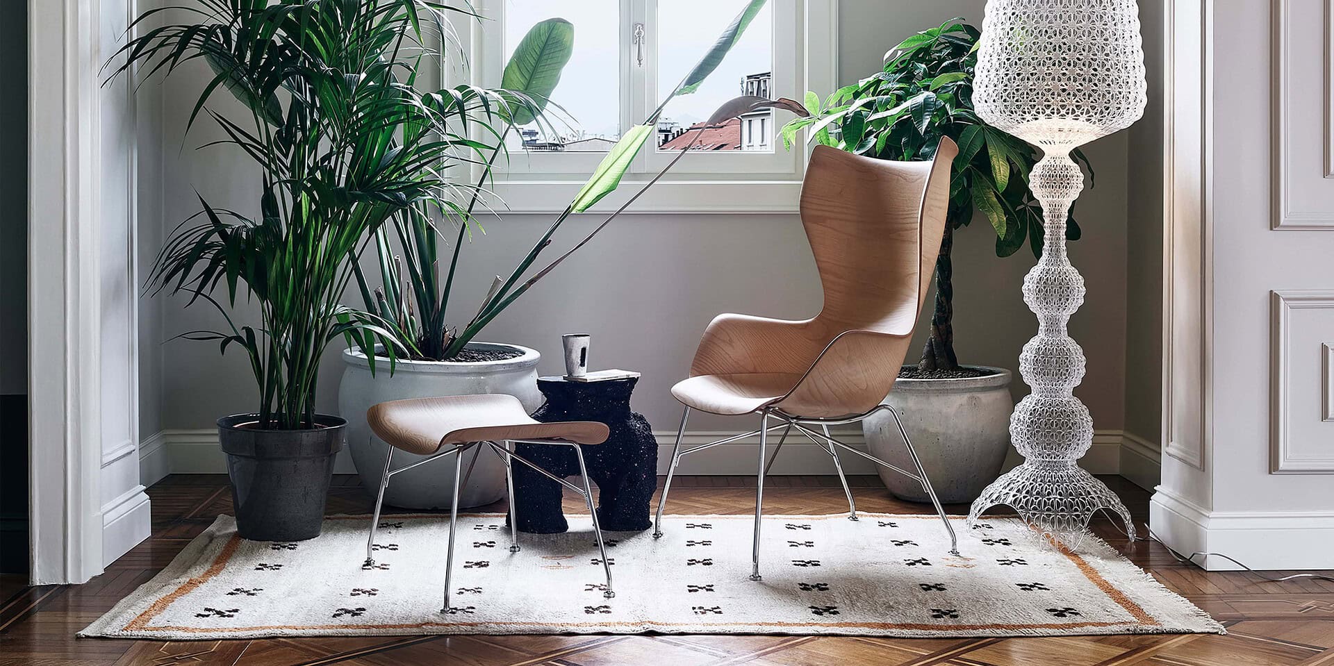 Contemporary Scandinavian-inspired living space with wooden chairs, lush plants, and decorative lighting.