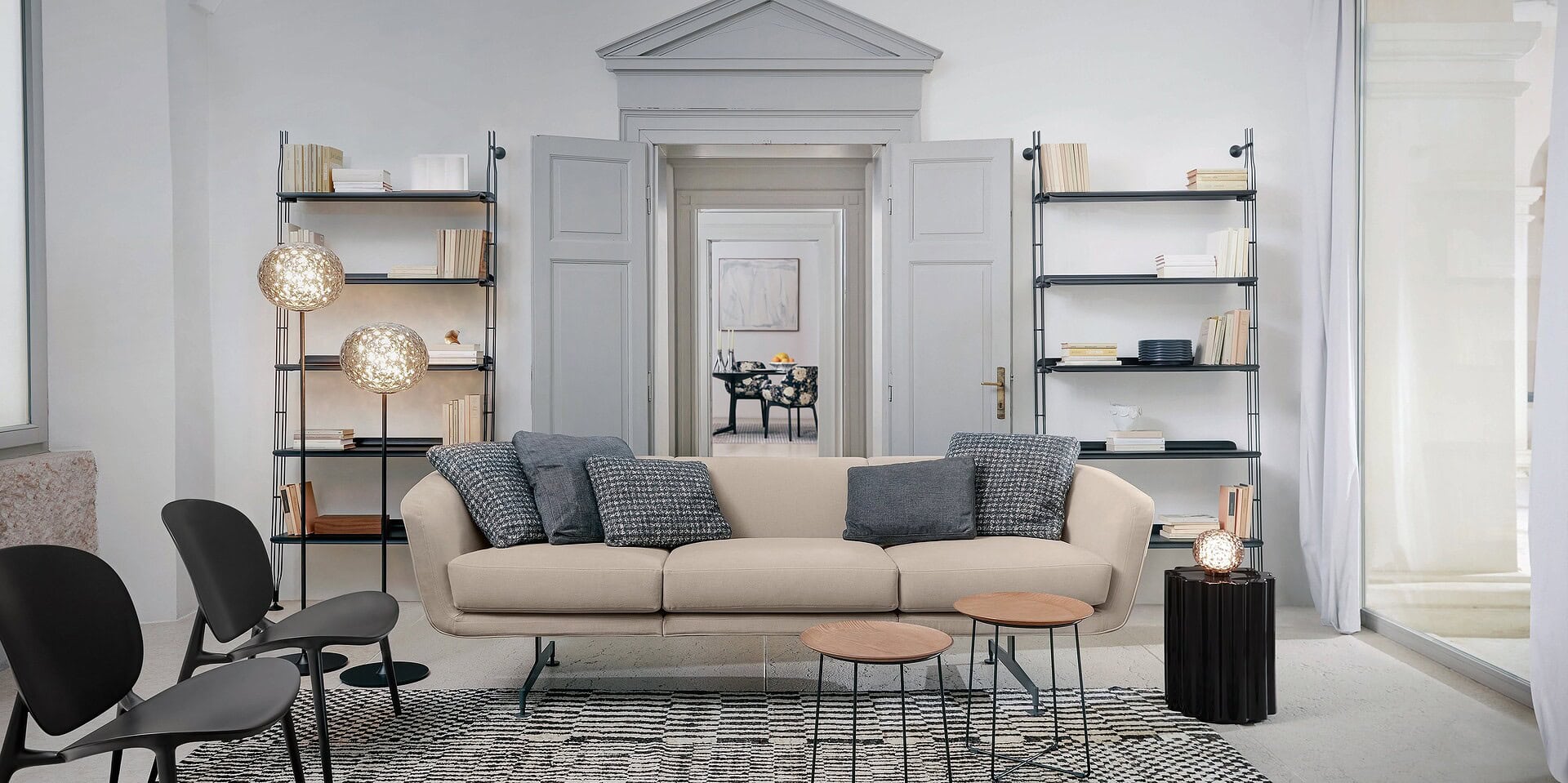 Contemporary living room with beige sofa, modern shelving, and stylish decor by Sklar Furnishings.
