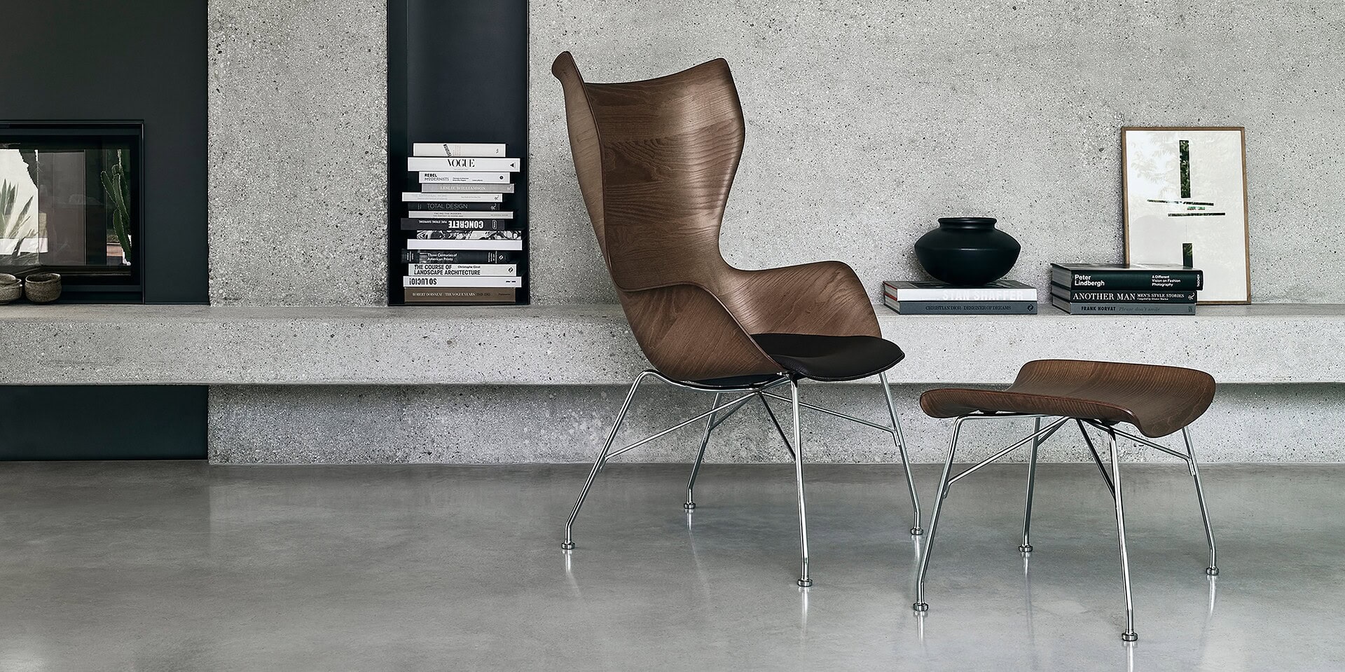 Sleek modern designer lounge chair and matching ottoman with wooden finish and metal legs in contemporary home setting.