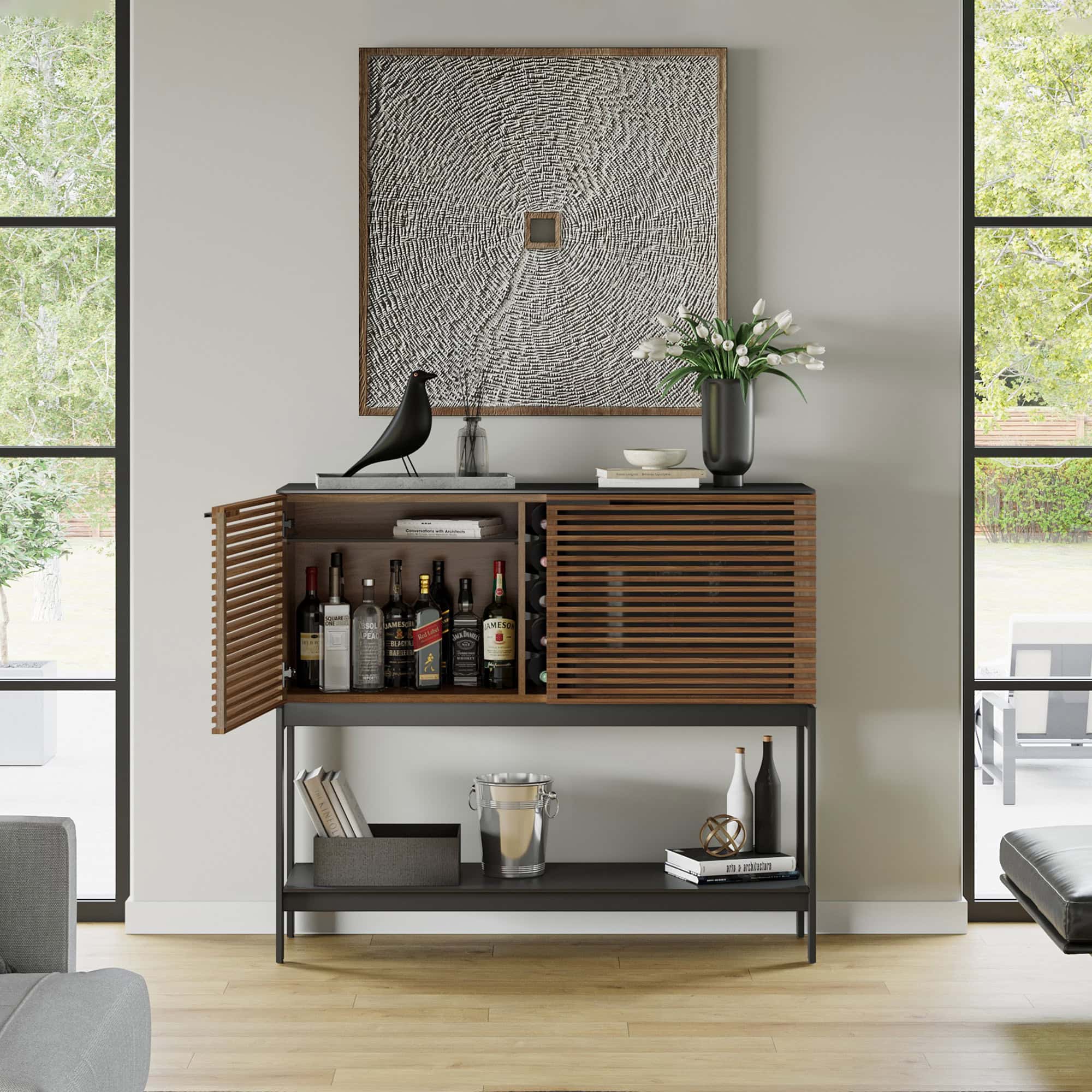 Contemporary wooden bar cabinet with slatted doors, decorative accessories, and art piece backdrop.
