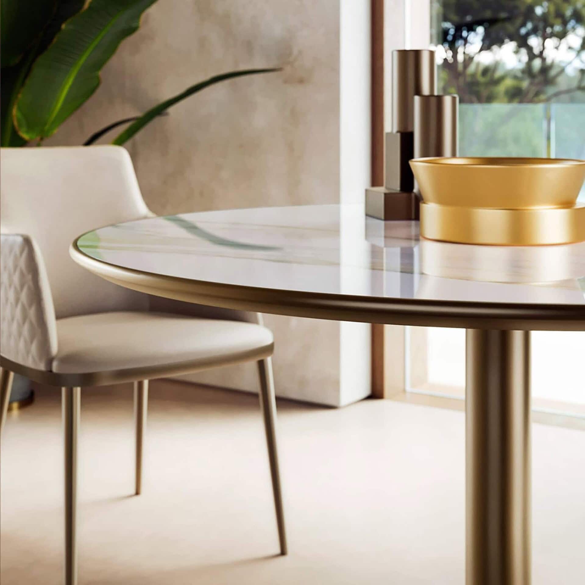 Close-up of Cilindro Bistro Table with round marble top and gold cylindrical base.