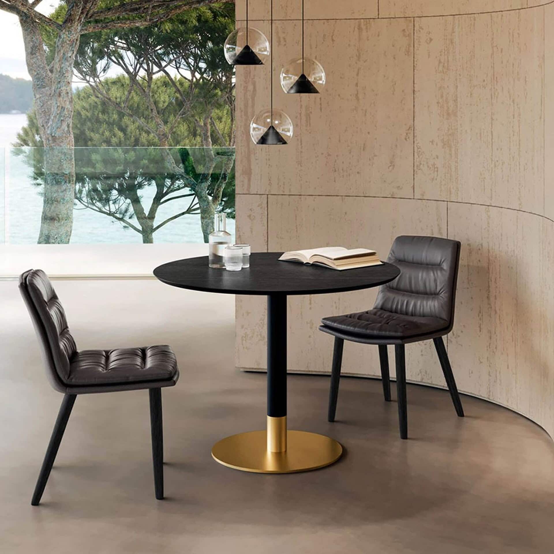 Cilindro Bistro Table with gold base and marble top set in a cozy dining corner.
