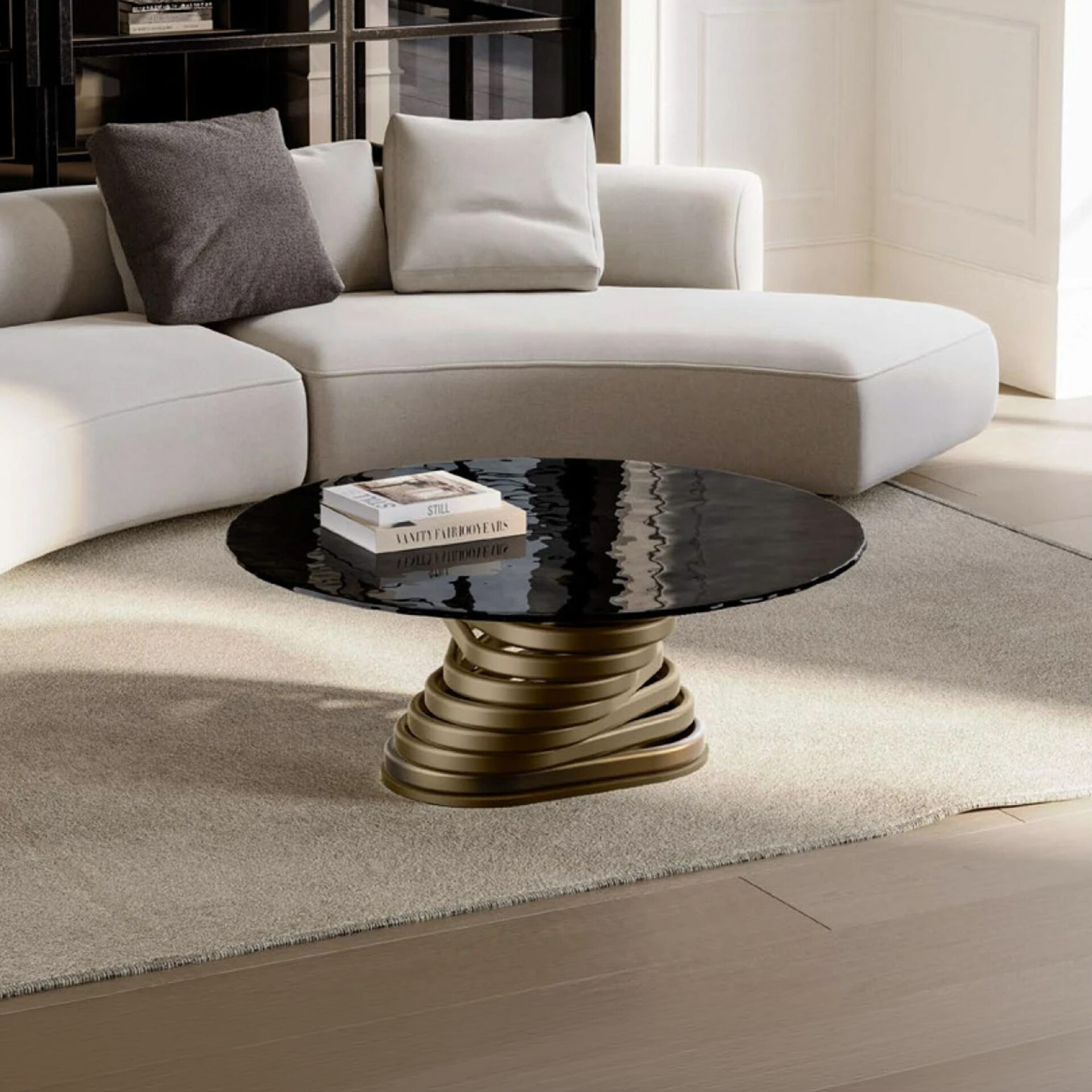 A modern living room with a cream sectional sofa, a black wavy-textured round coffee table with a bronze spiral base, and a light beige rug on a wooden floor.