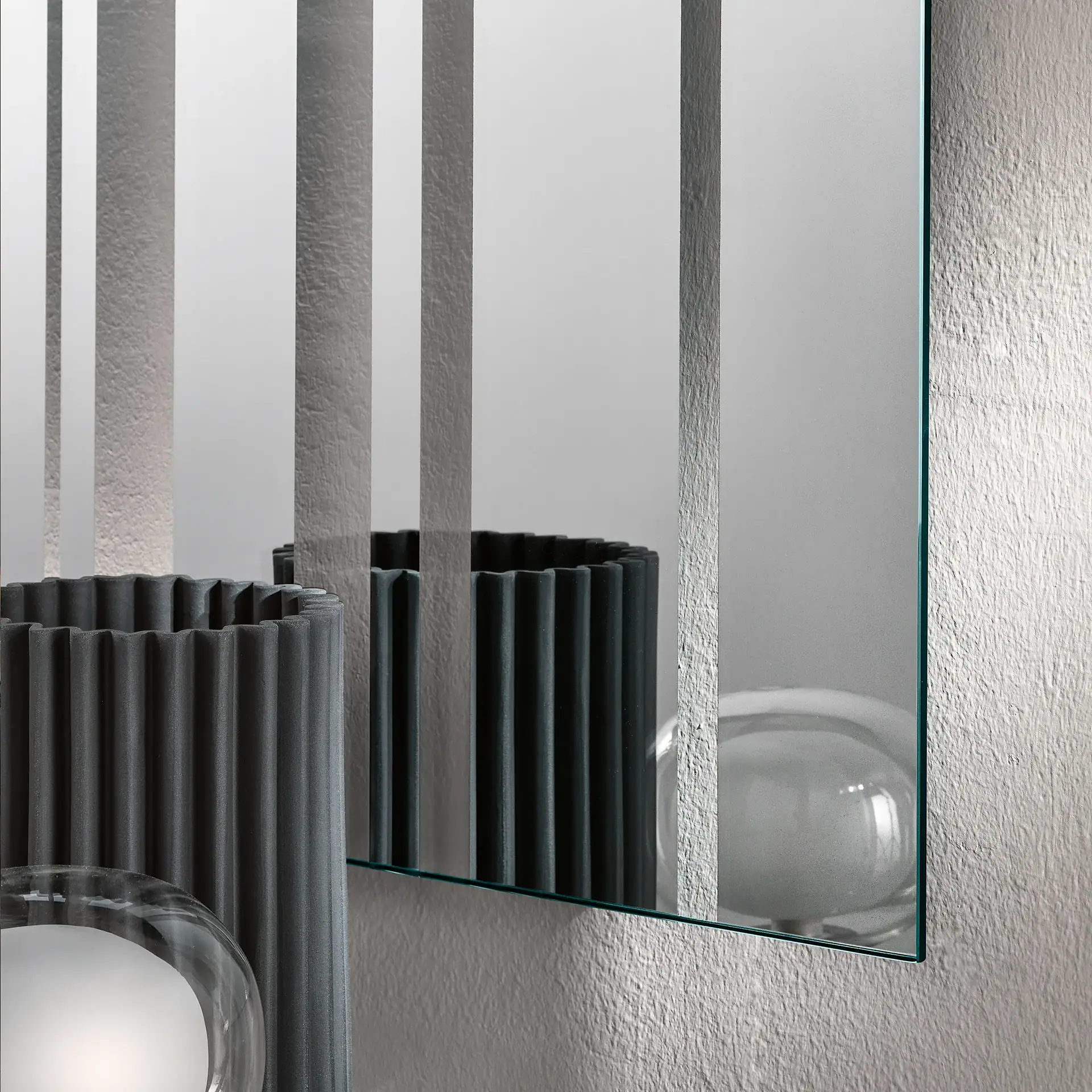 Close-up of a modern wall mirror with vertical metal bars and a reflective surface.