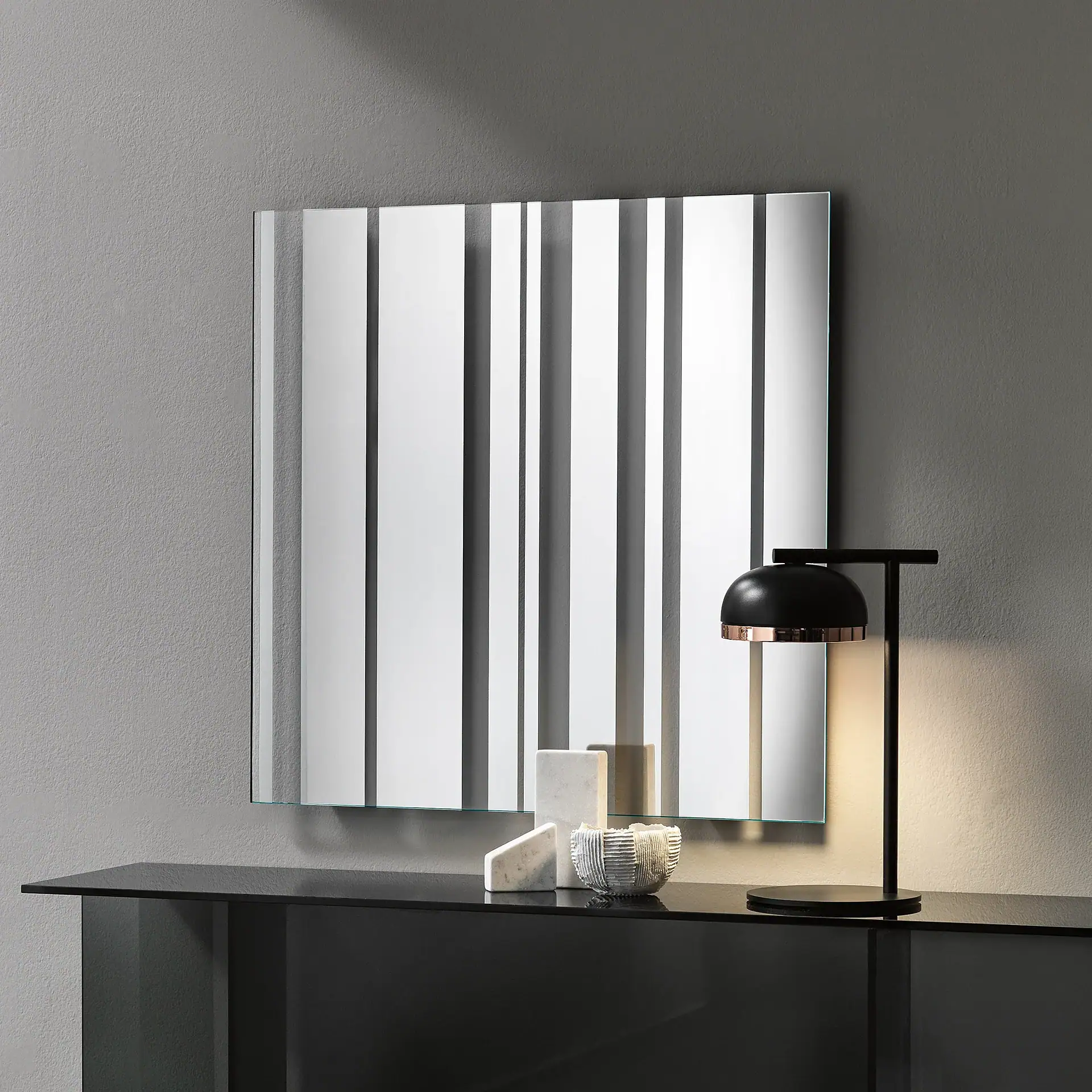 Barcode wall mirror with vertical stripes on a gray wall.