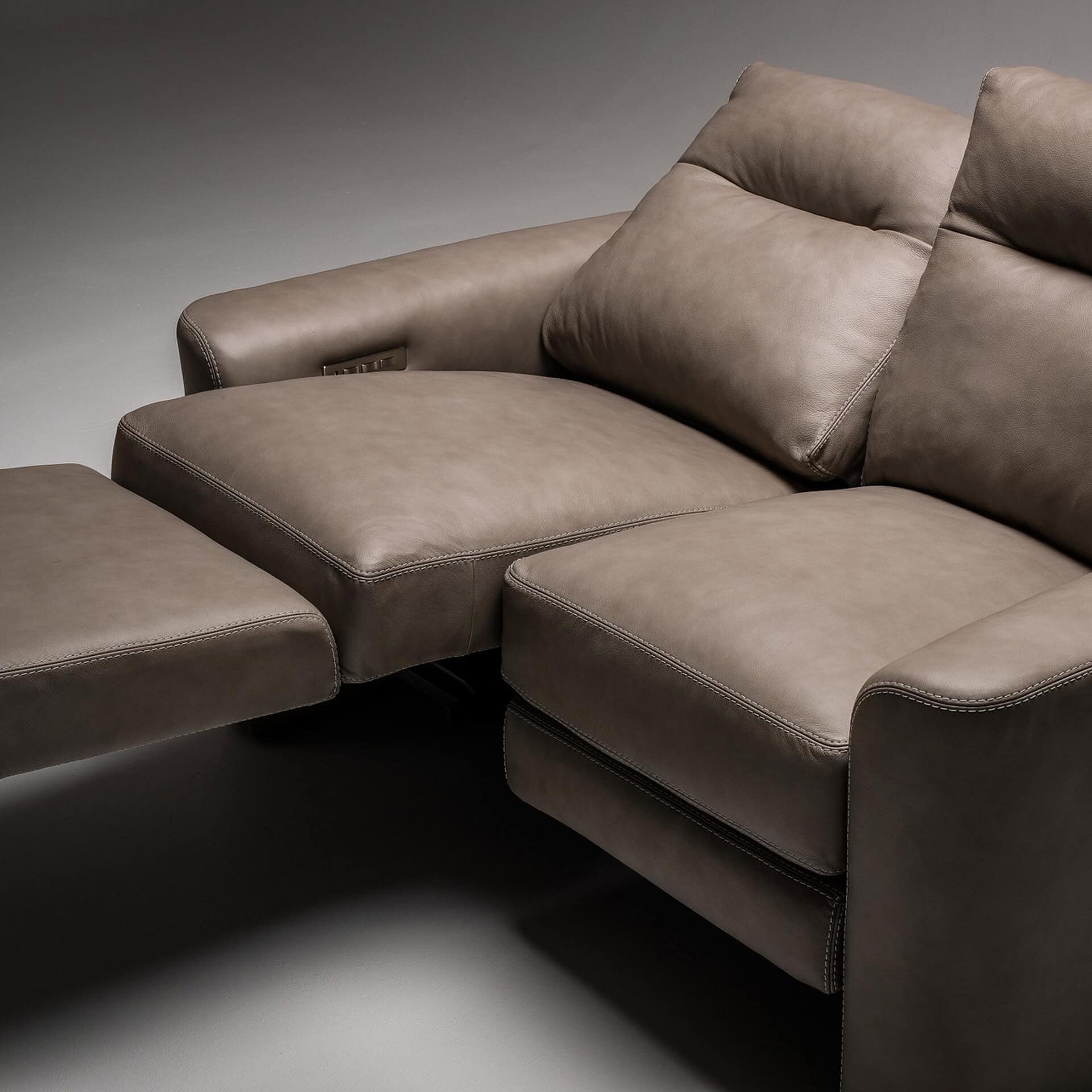 Taupe leather sectional sofa with plush cushions and sleek design.