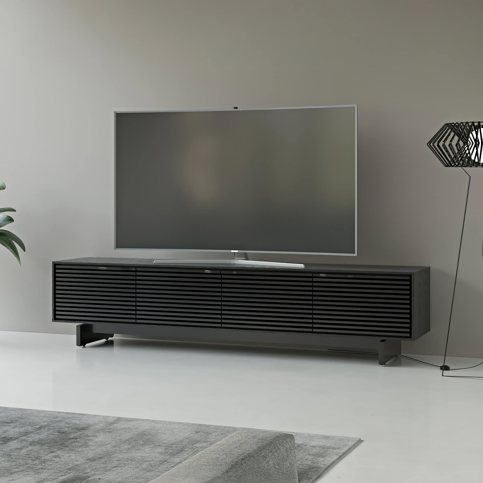 Sleek black modern TV media console with slatted doors for a minimalist living room style.