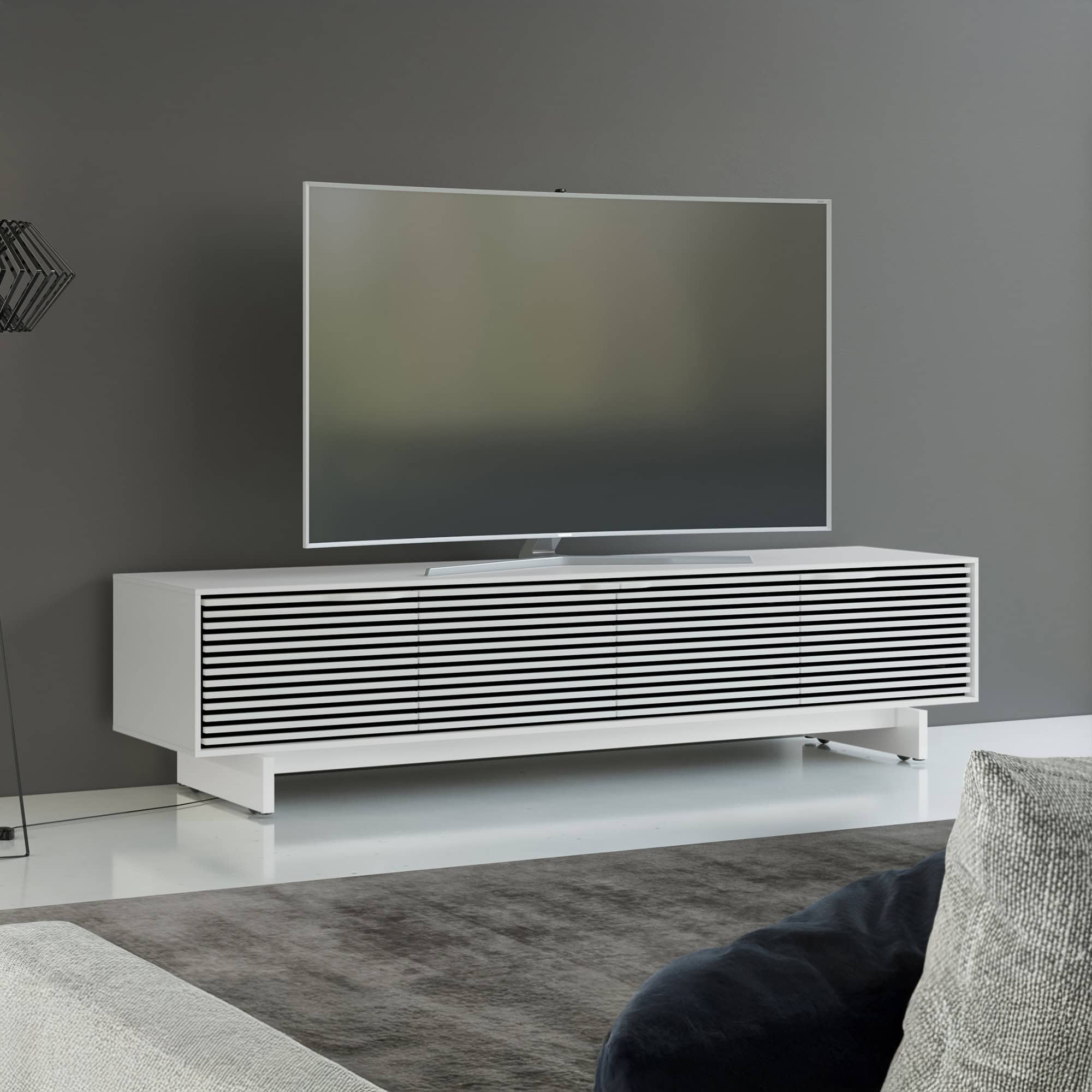Sleek modern white TV console with black slatted doors, perfect for stylish entertainment setups.