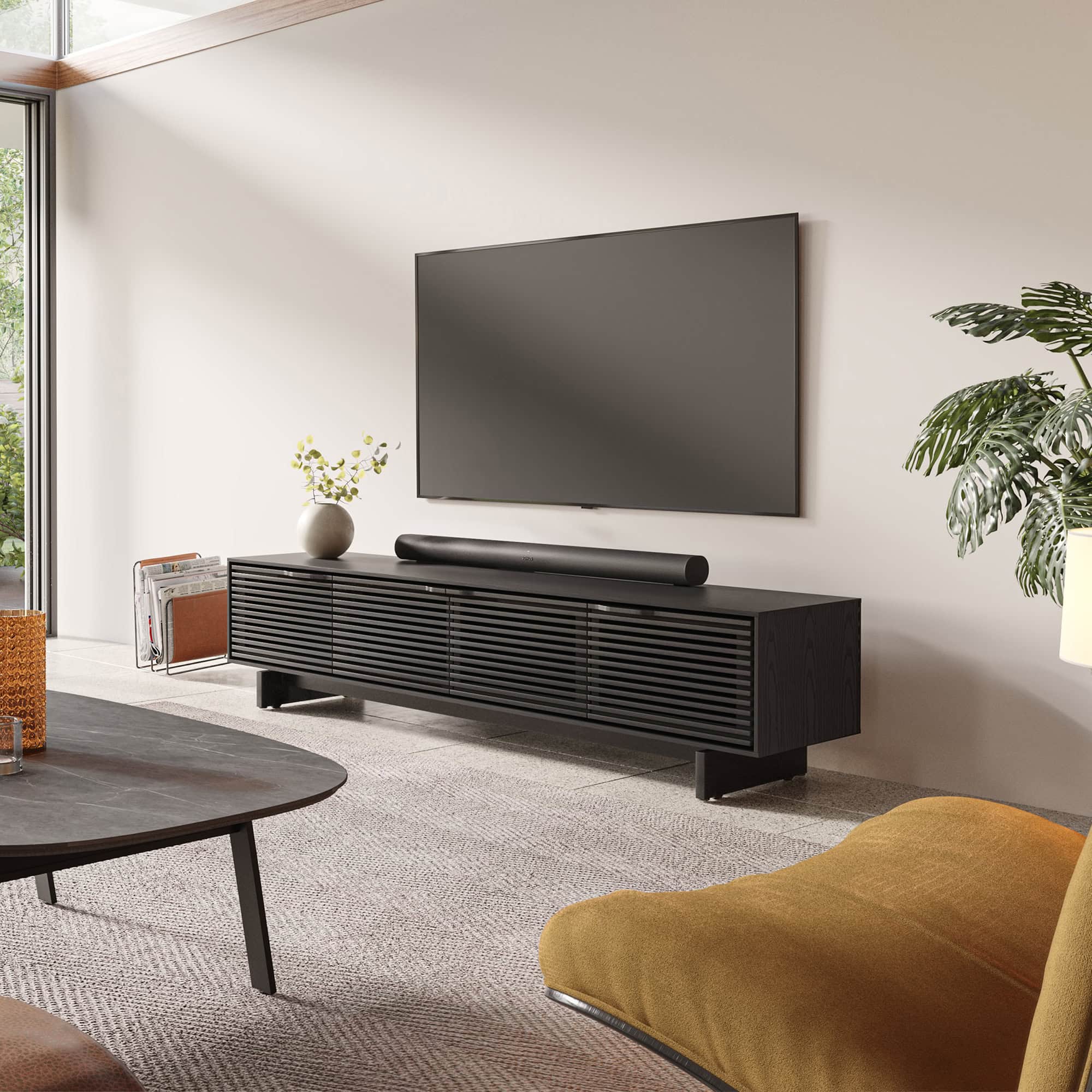 Sleek modern black media console with slatted doors in contemporary living room setup.