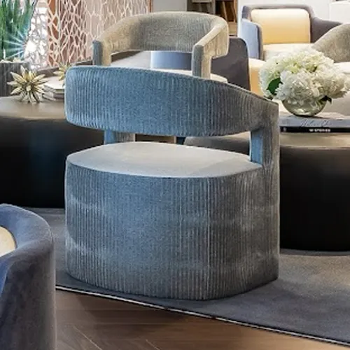 A light blue-gray ribbed armchair with curved back and armrests, and a light seat cushion, in a modern living room setting.