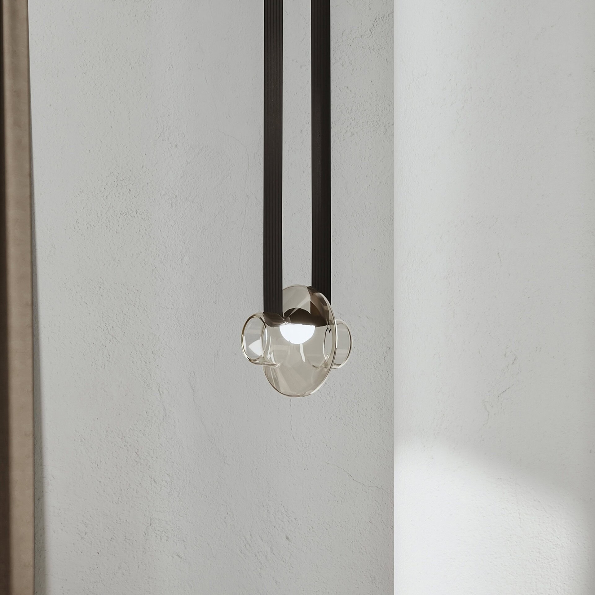 Sleek modern pendant light with glass and black accents, ideal for contemporary interior design.
