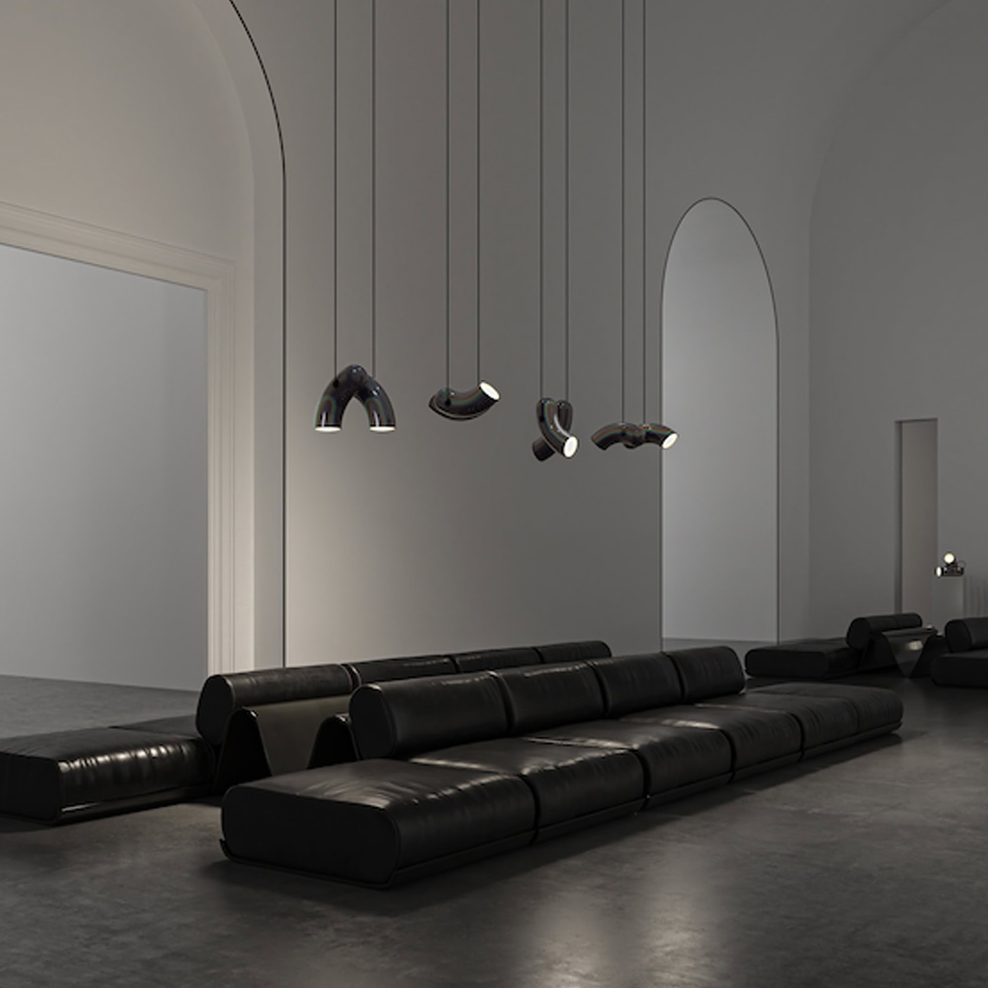 Modern black leather sofa with designer pendant lighting in minimalist interior.