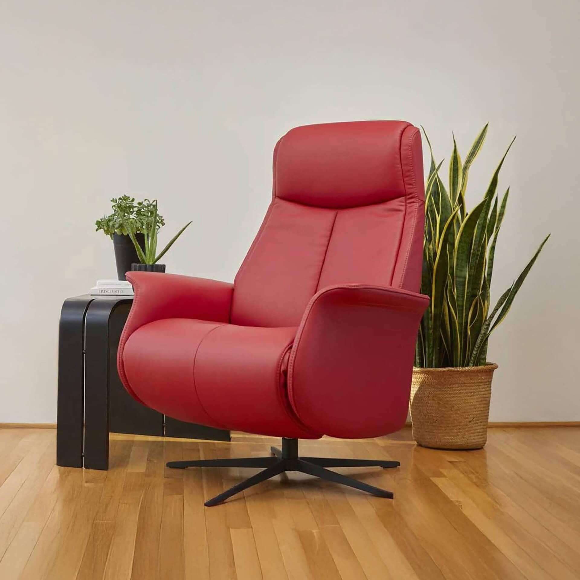 Fjords Jakob Recliner in red leather, displayed in a modern living space with wood flooring and green plant.