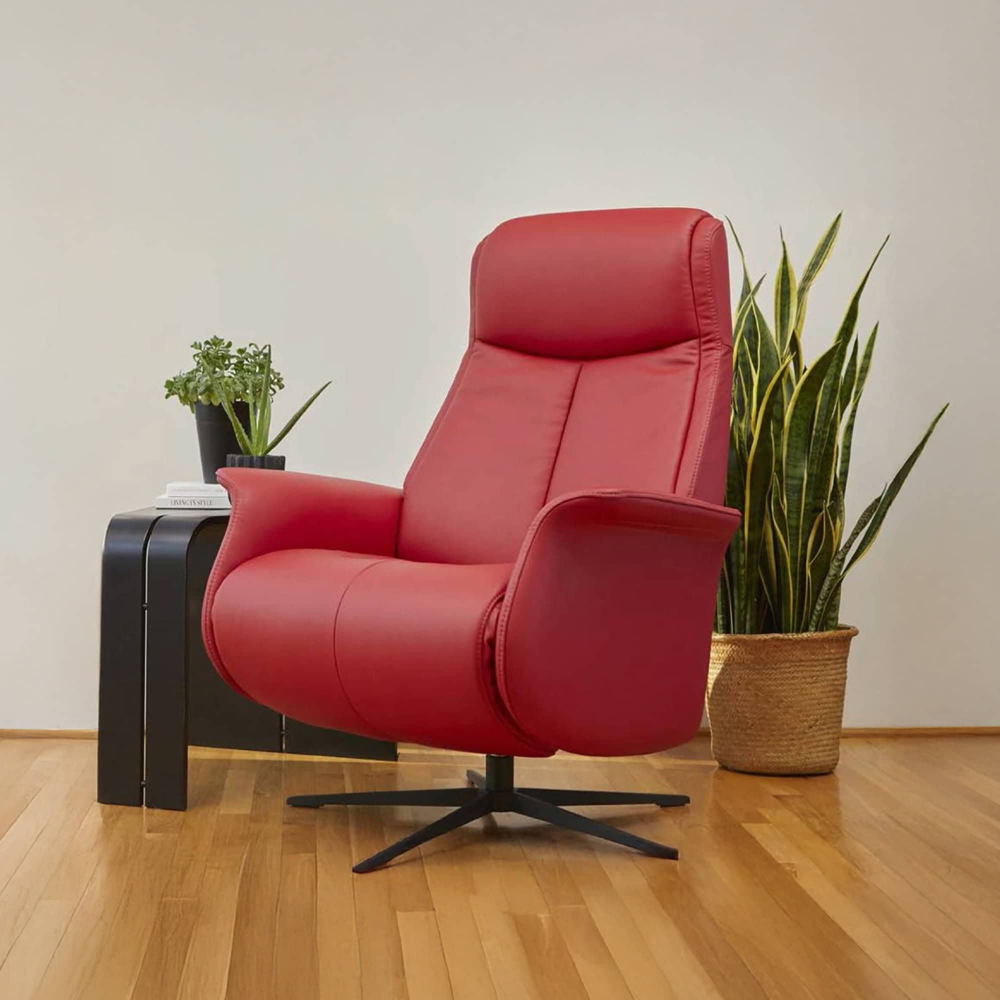 Fjords Jakob Recliner in red leather, displayed in a modern living space with wood flooring and green plant.