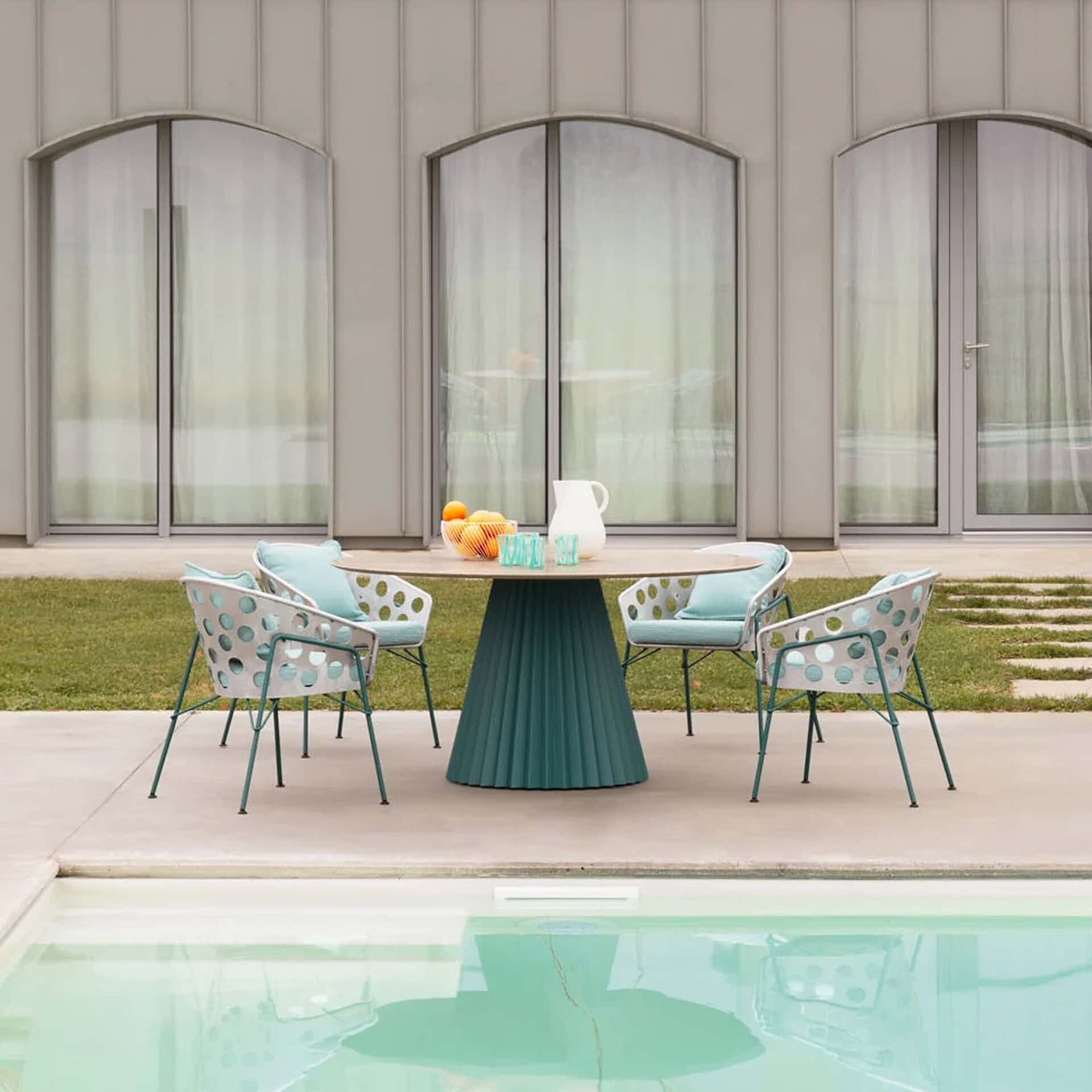 Outdoor round dining table with modern design and teal finish.