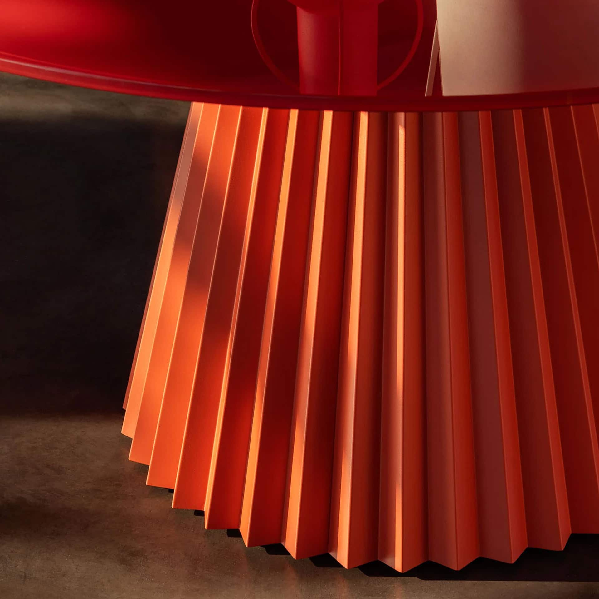 Elegant plissé round dining table with a modern design and vibrant red finish. Perfect for contempor.