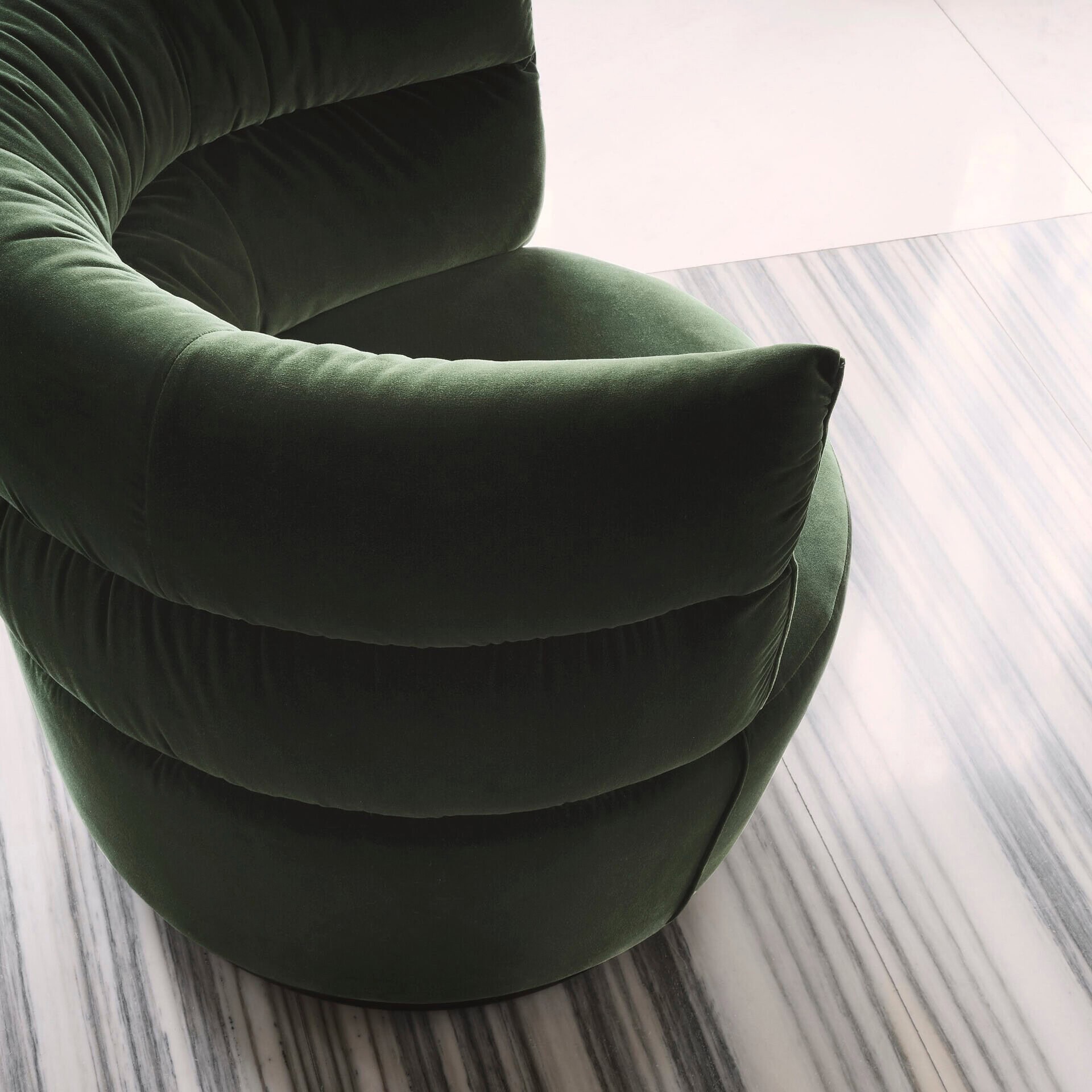 Elegant green velvet armchair with plush cushioning and modern design.