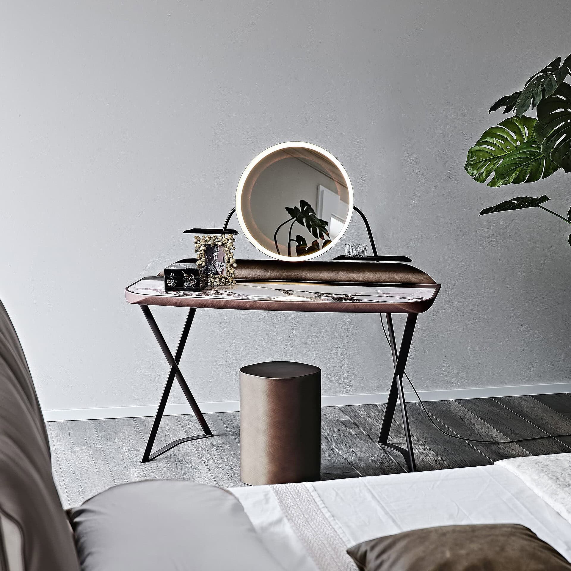 Detail view of vanity top in brushed bronze with integrated groove tray and round mirror.