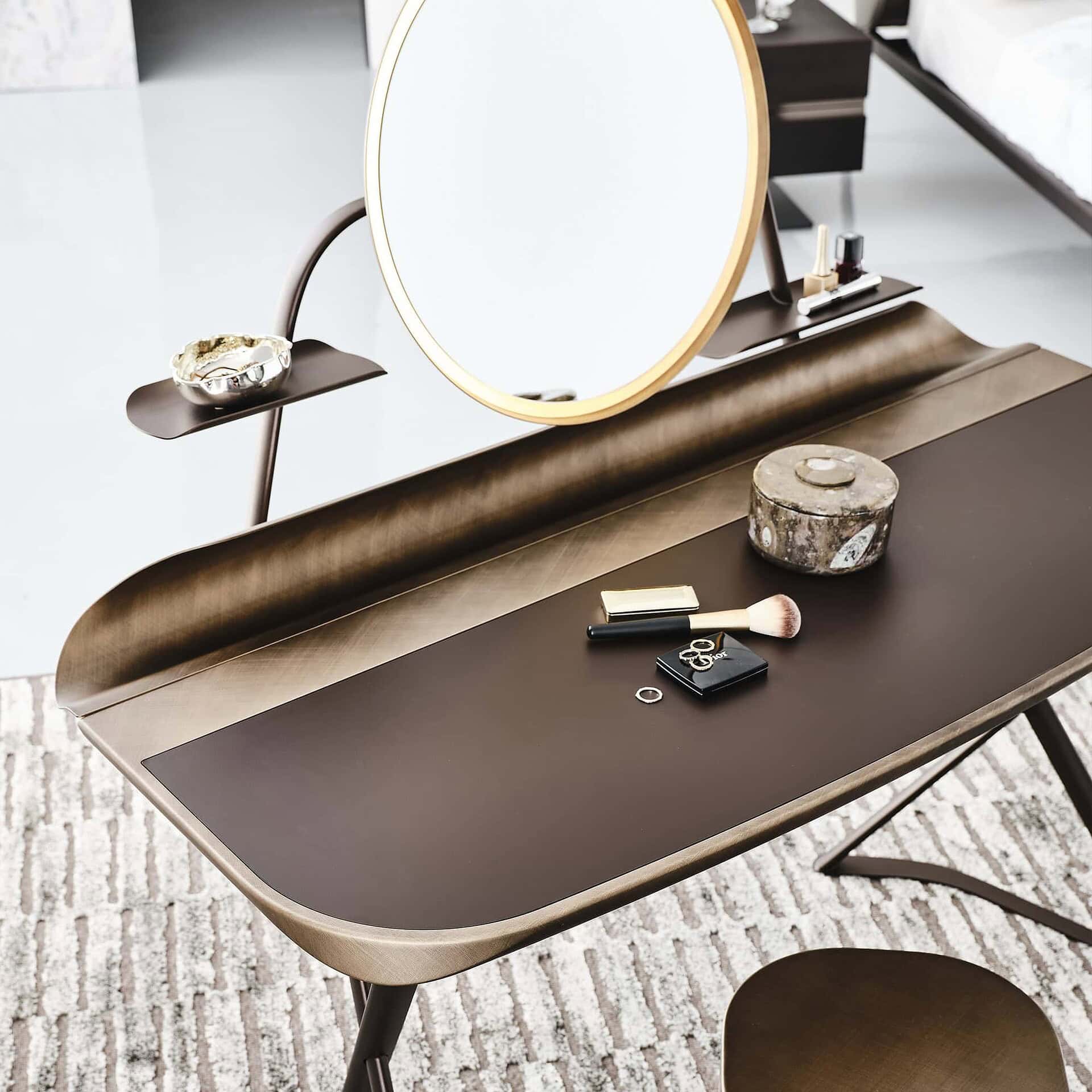 Close-up of vanity corner showing marble-effect ceramic surface and brushed bronze profile.