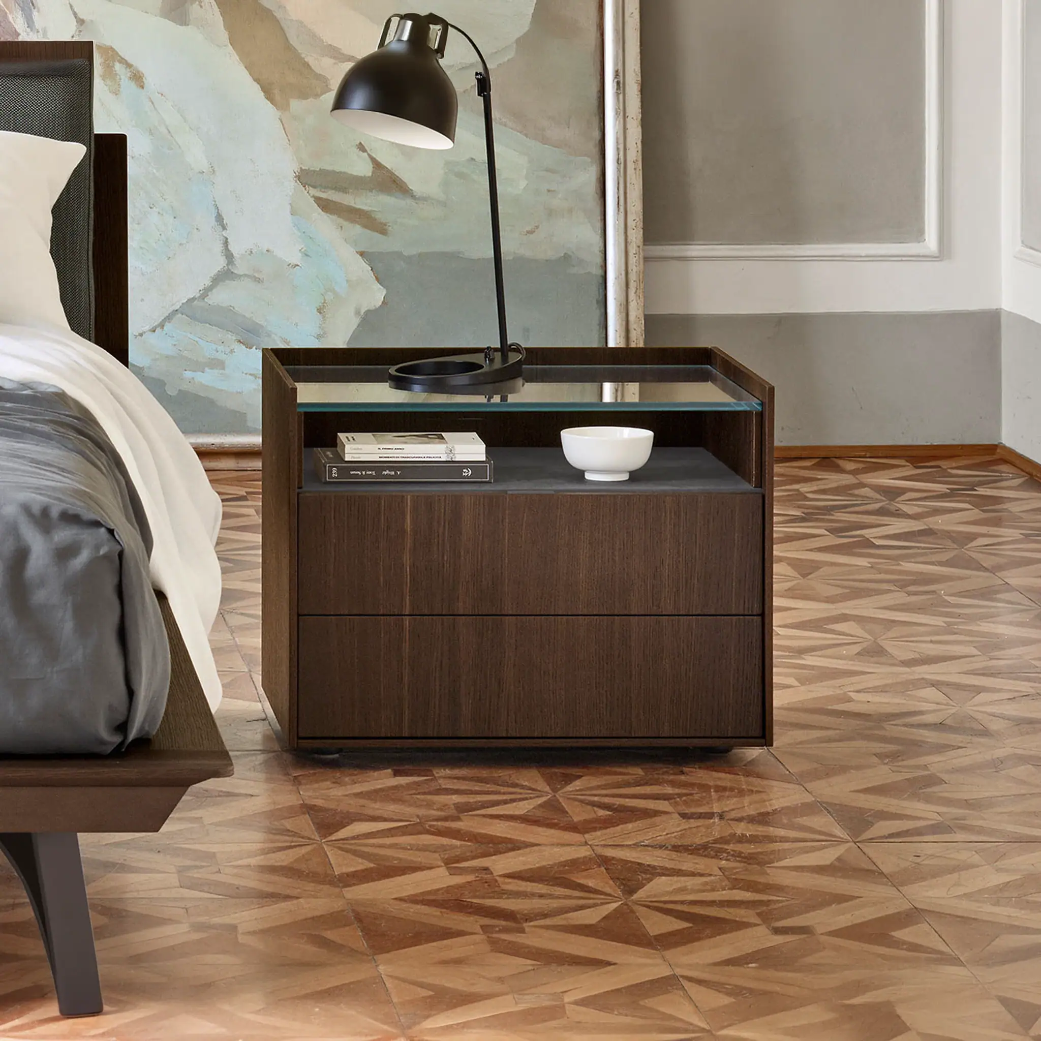 Walnut nightstand featuring a sleek design, with a black desk lamp and decorative bowl, perfect for.