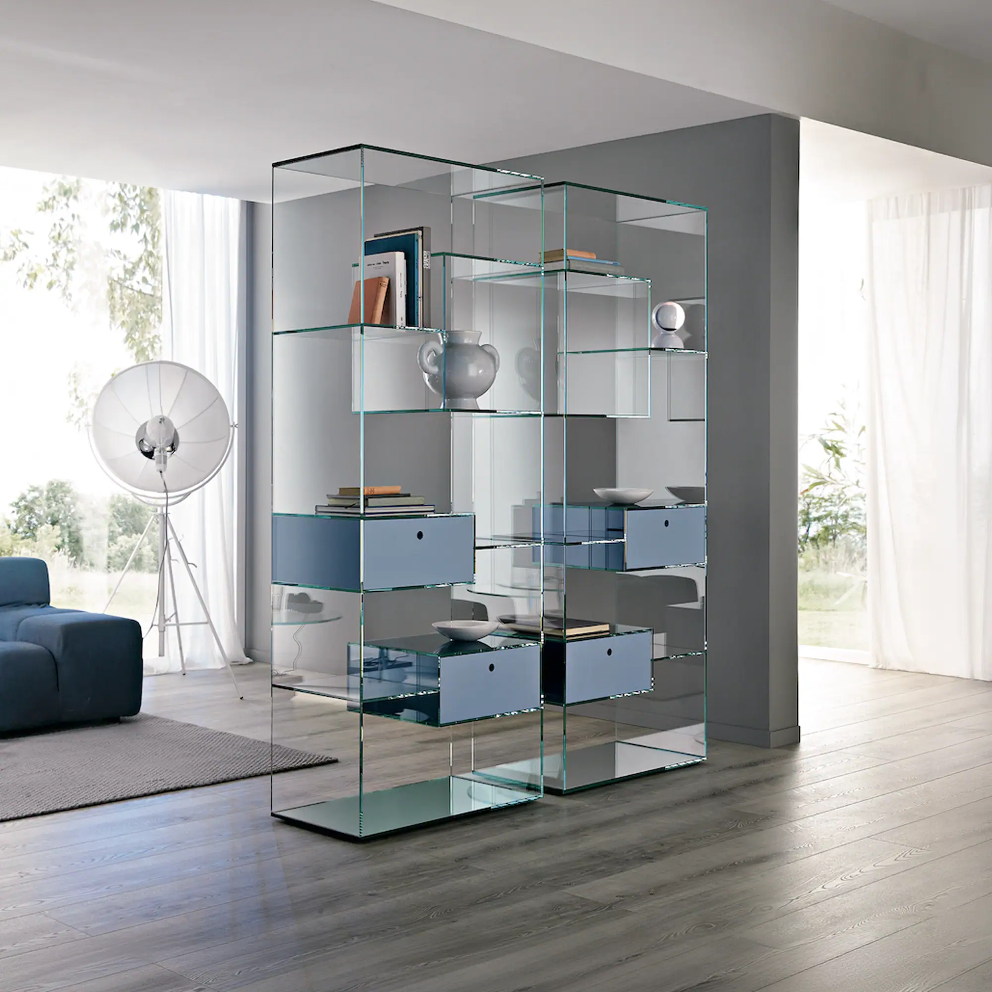 Sklar Furnishings glass bookcase with decorative items in modern living room.