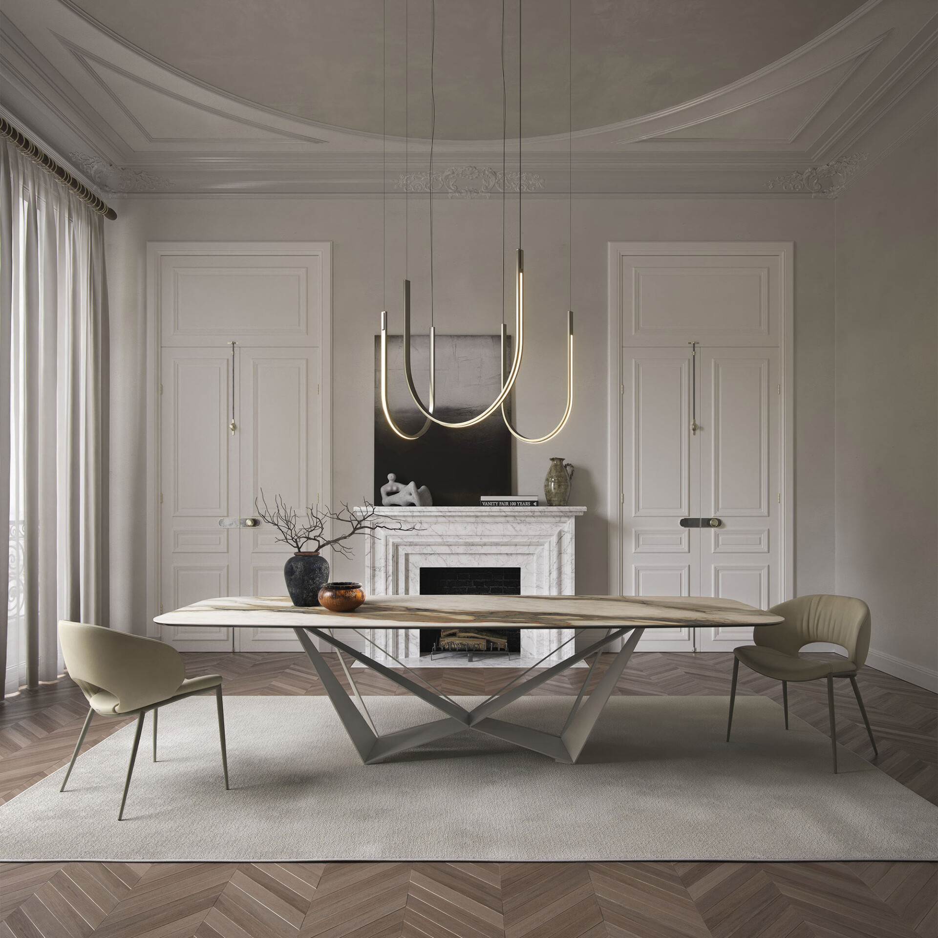 A luxurious dining room featuring a modern marble-topped table with a geometric base, contemporary chairs, and sculptural pendant lights. The room has classic architectural details like paneled doors, a marble fireplace, and ornate ceiling moldings, all in a neutral color palette with dark wood herringbone flooring.