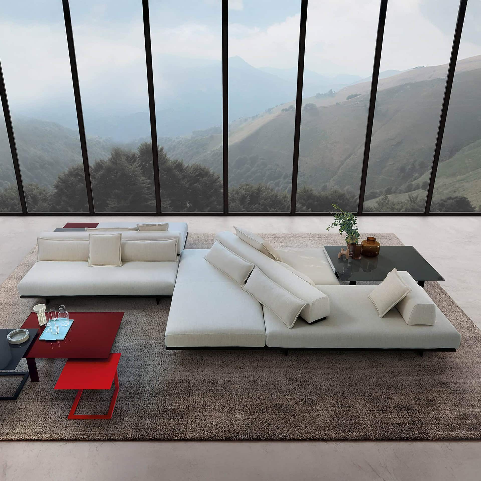 Contemporary white sectional sofa with plush cushions in a modern living room with panoramic mountain view.
