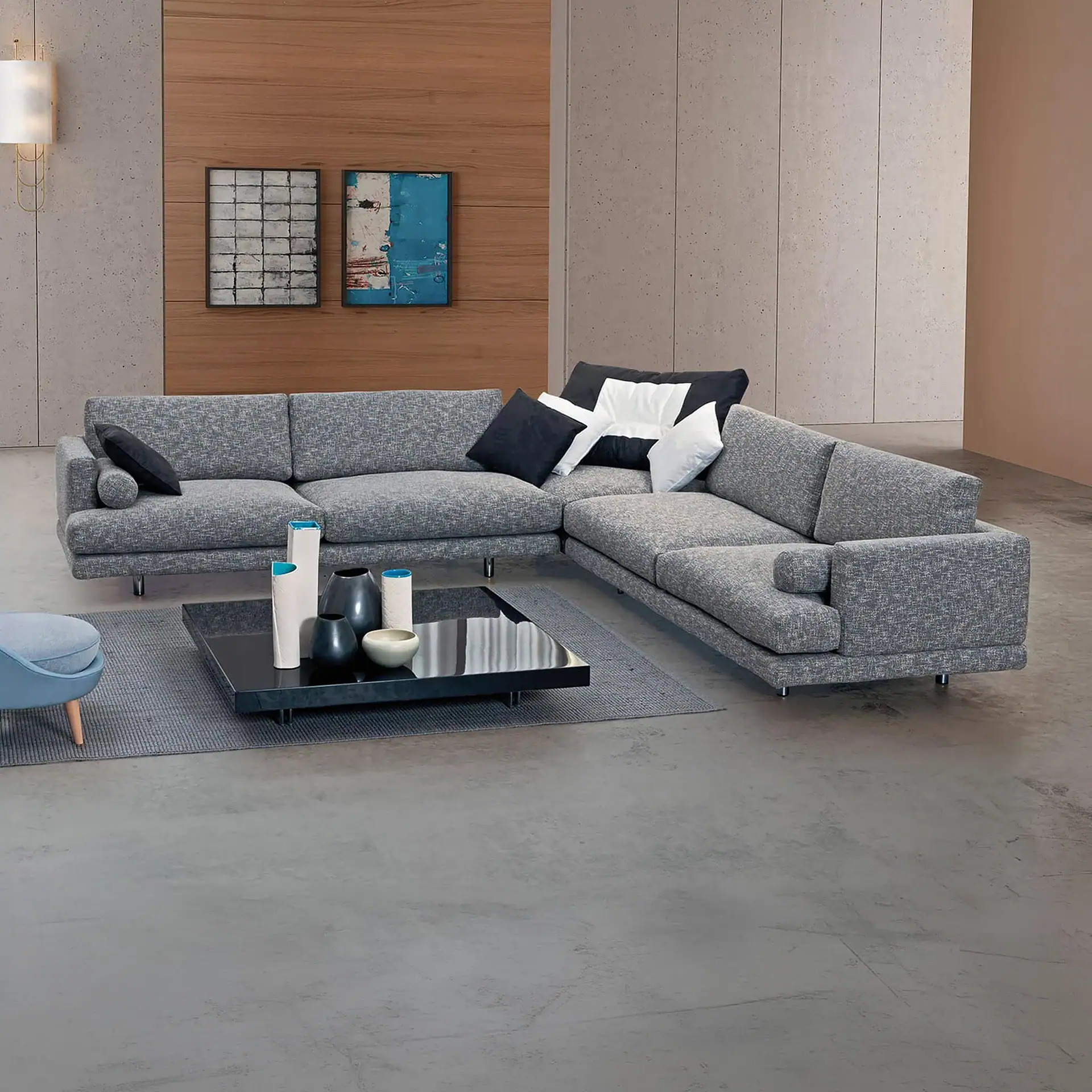 Modern gray sectional sofa with black and white accent pillows, in a contemporary living room setting.