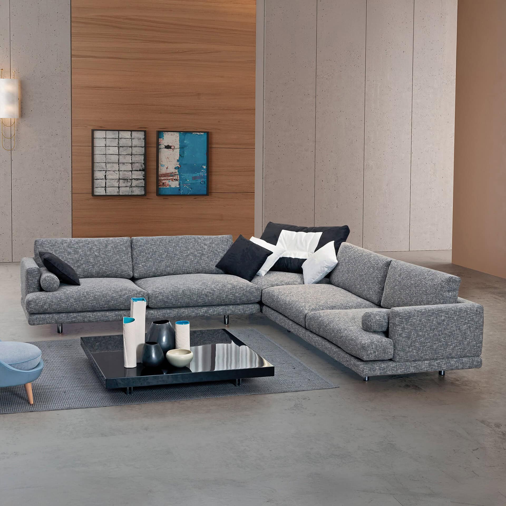 Modern gray sectional sofa with black and white accent pillows, in a contemporary living room setting.