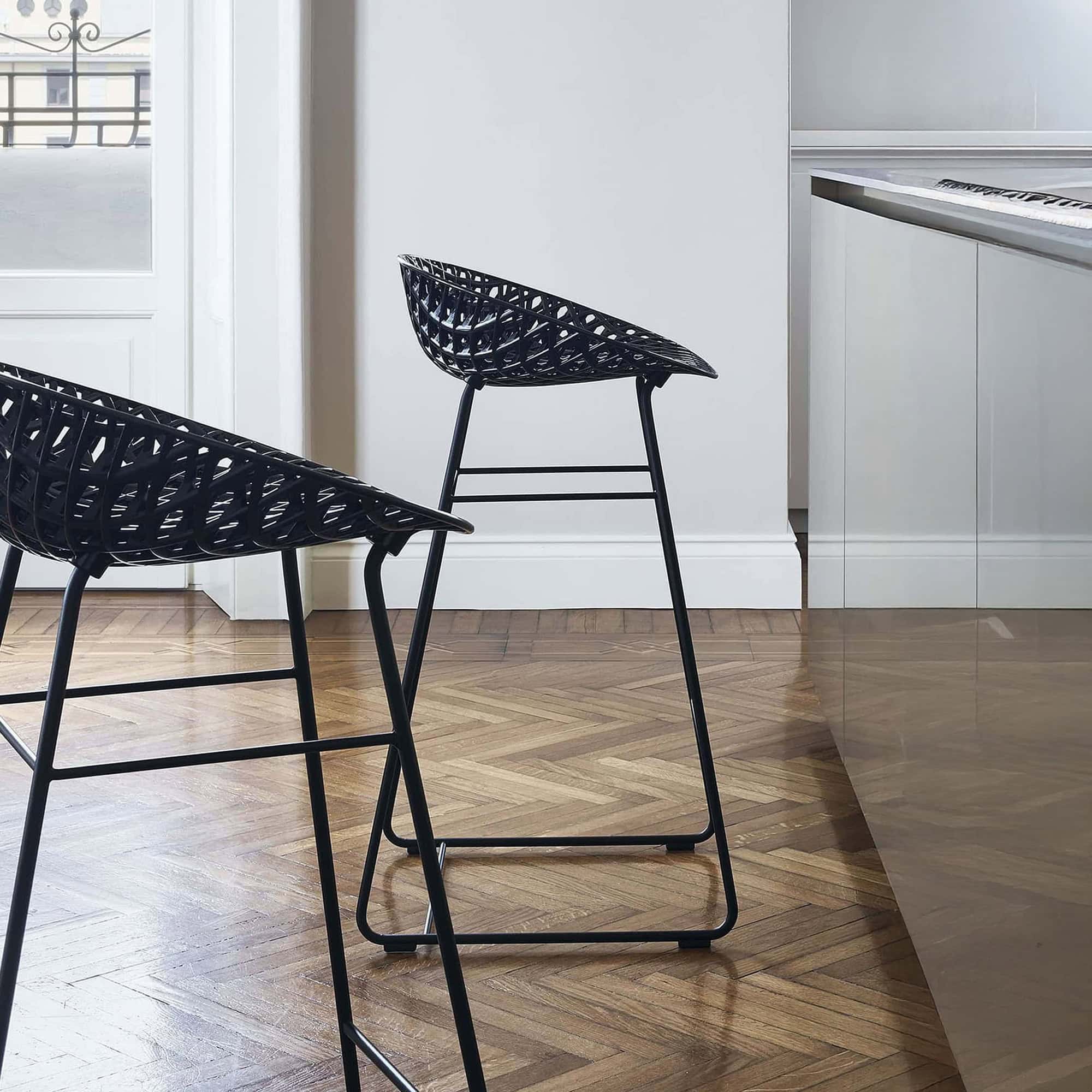 Black wire bar stool with sleek design and metal frame for contemporary interiors.