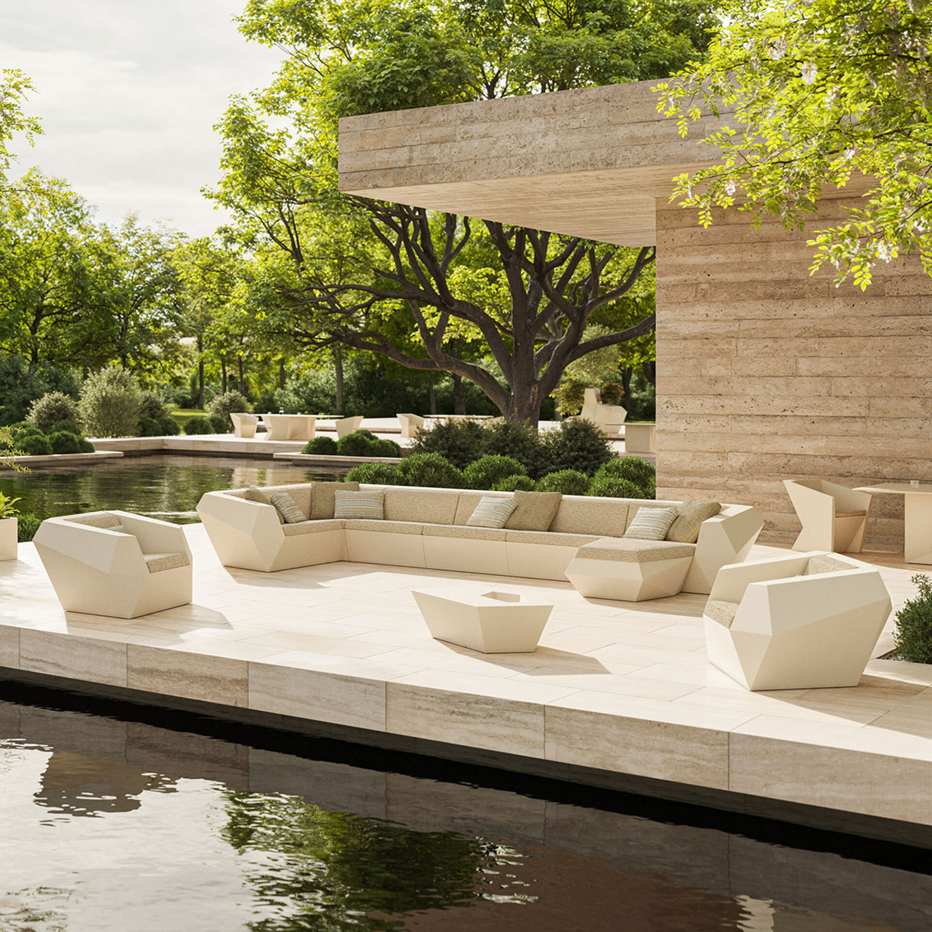 A luxurious outdoor patio with modern cream-colored geometric furniture, including an L-shaped sofa and armchairs, next to a dark pond. A light brown stone building and lush green trees are in the background under a bright sky.