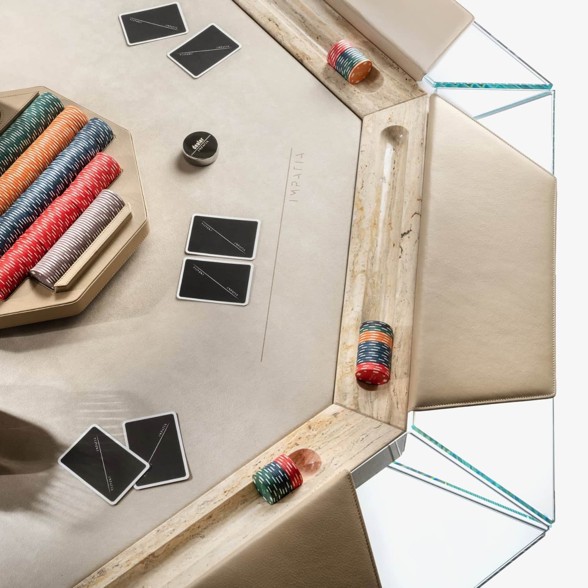 Colorful poker chips and playing cards on luxurious casino table with leather edges.