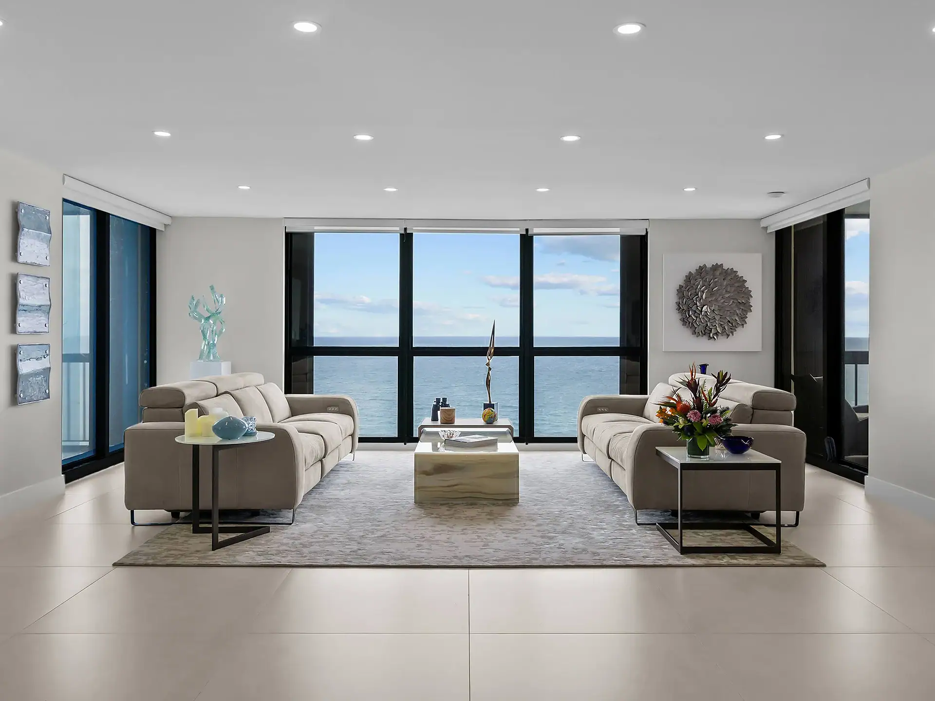 Ocean view living room with contemporary furniture and large windows.