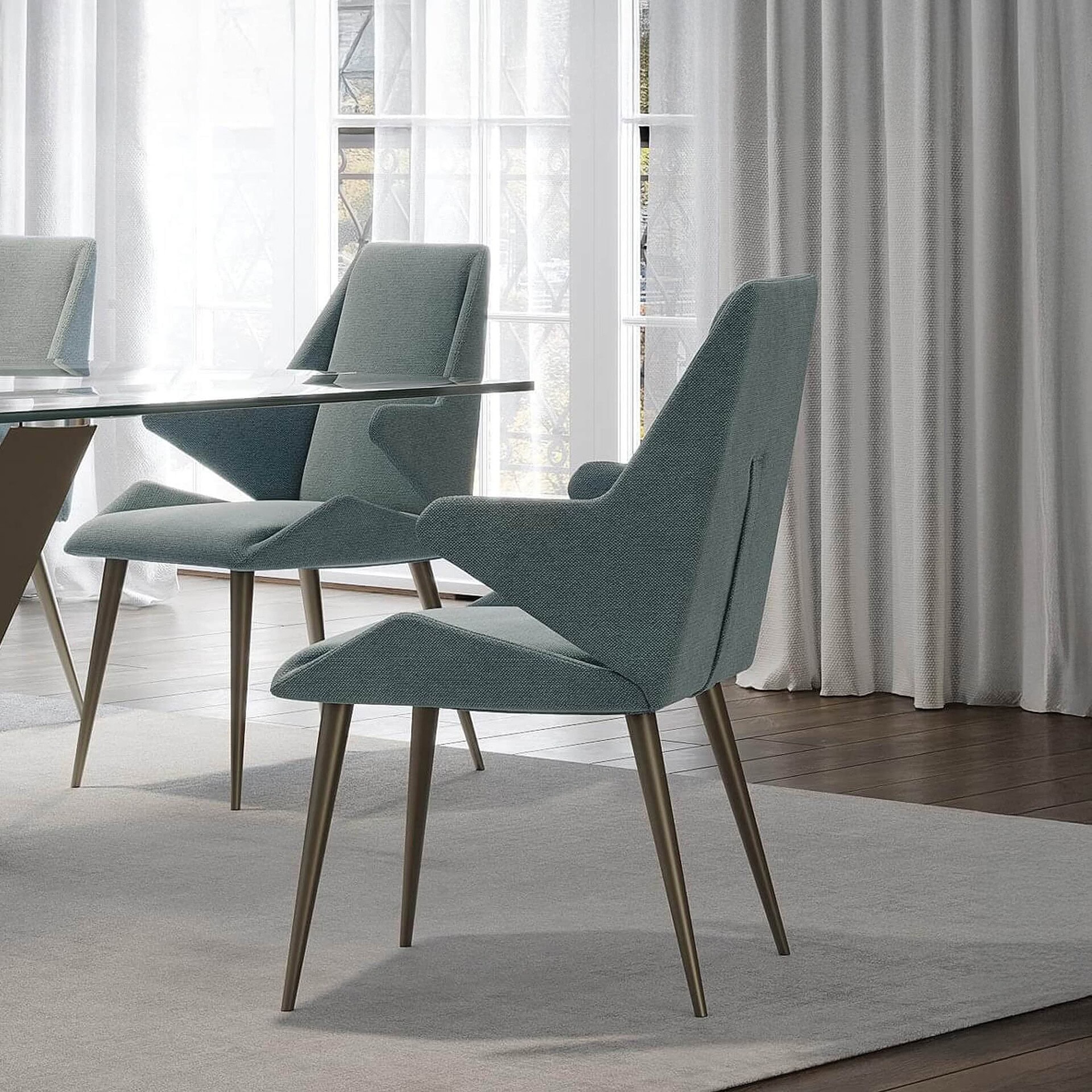 Dining room scene with multiple Origami Upholstered Dining Chairs around a table, upholstered in light fabric with wooden legs.