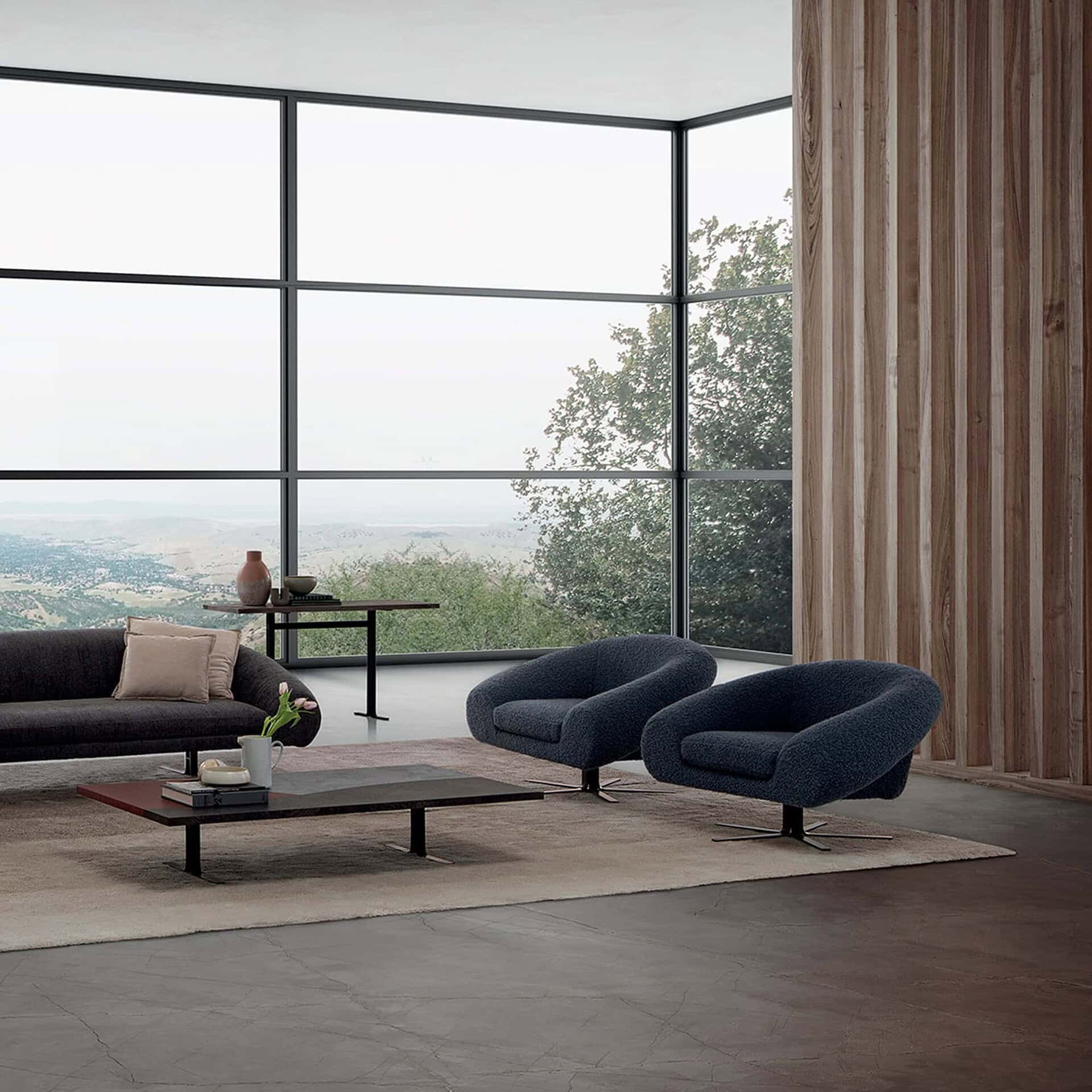 Airstrike Swivel Armchair in dark blue upholstery with clean modern architectural surroundings.