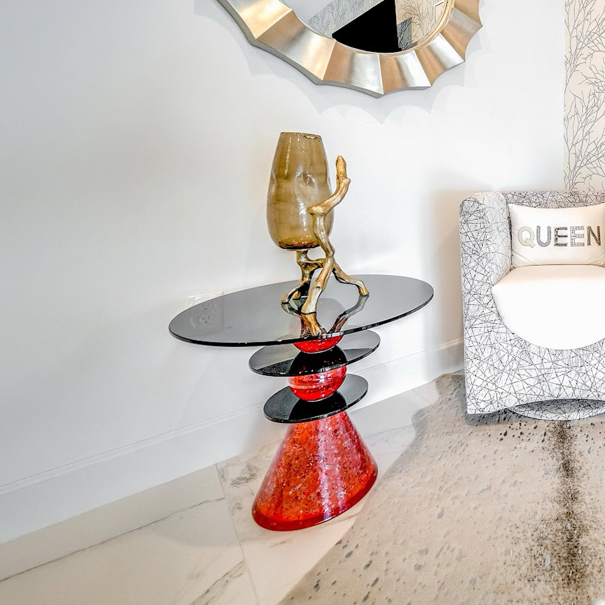 Elegant modern side table with artistic glass and metal design in a contemporary living room.