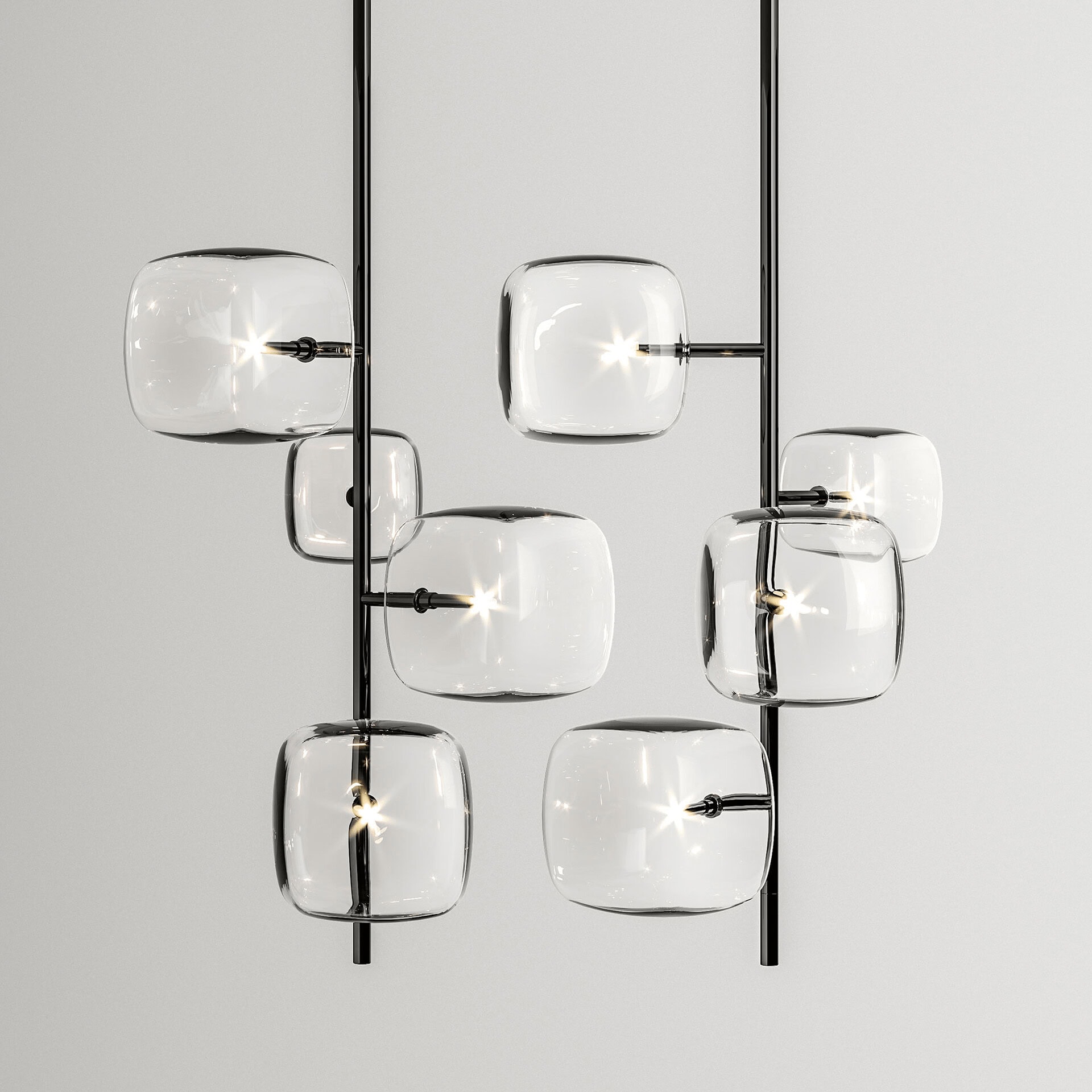 A modern multi-pendant light fixture with eight clear, rounded square glass pods attached to glossy black vertical rods, glowing brightly against a light gray wall.