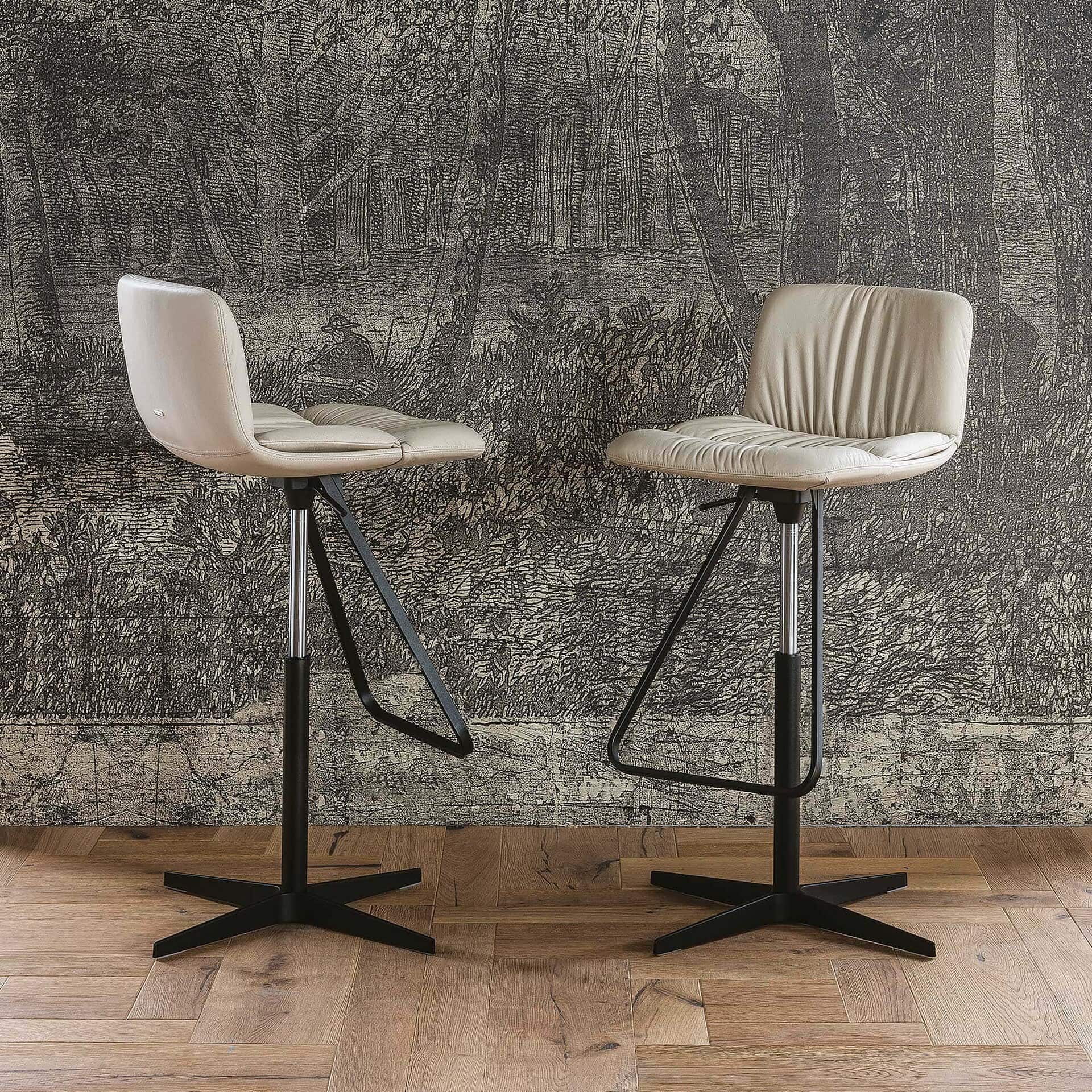 Pair of Axel X Adjustable Swivel Stools with black metal bases in a dining room setting