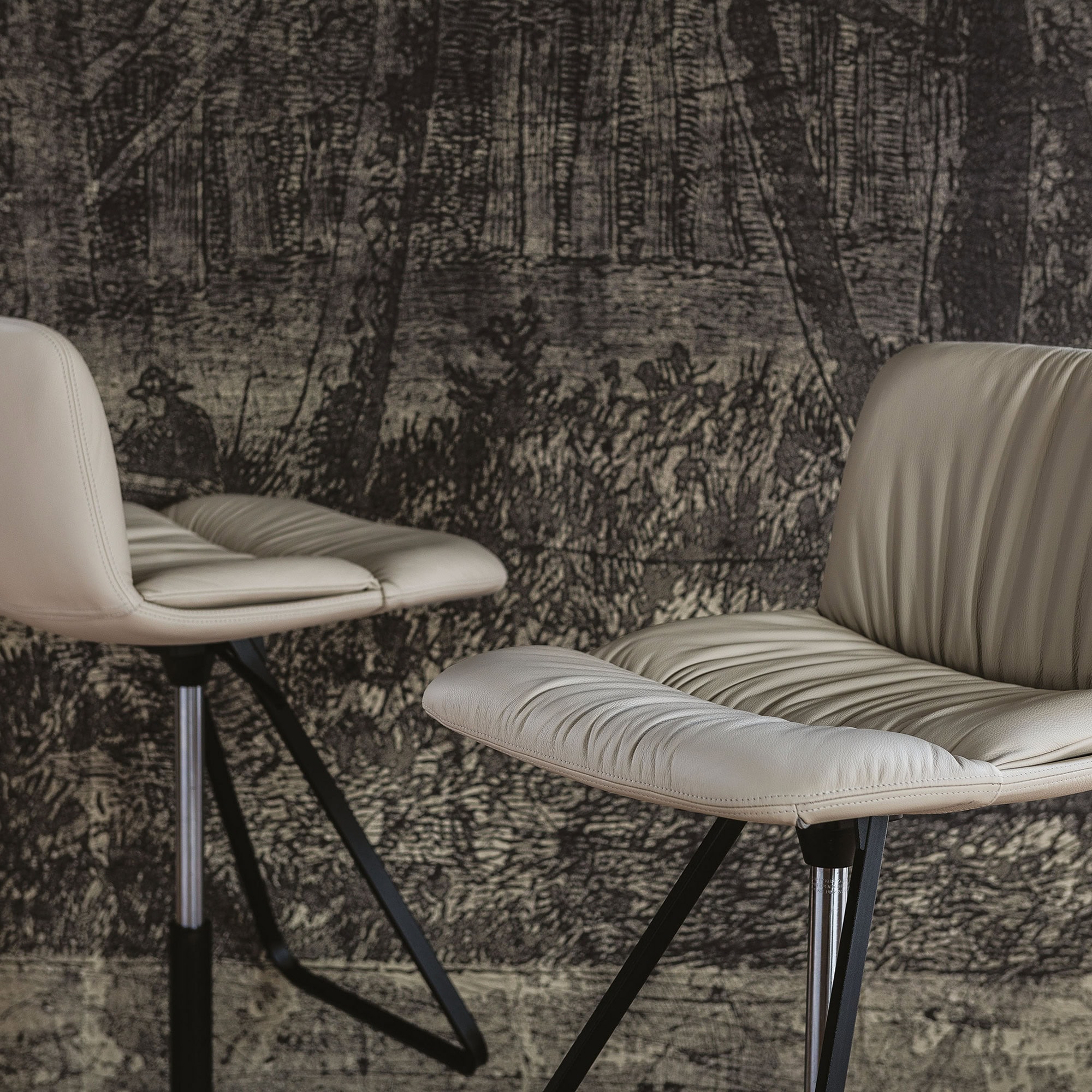 Pair of Axel X Stools featuring sleek upholstery and cross-style metal bases in a room setting.