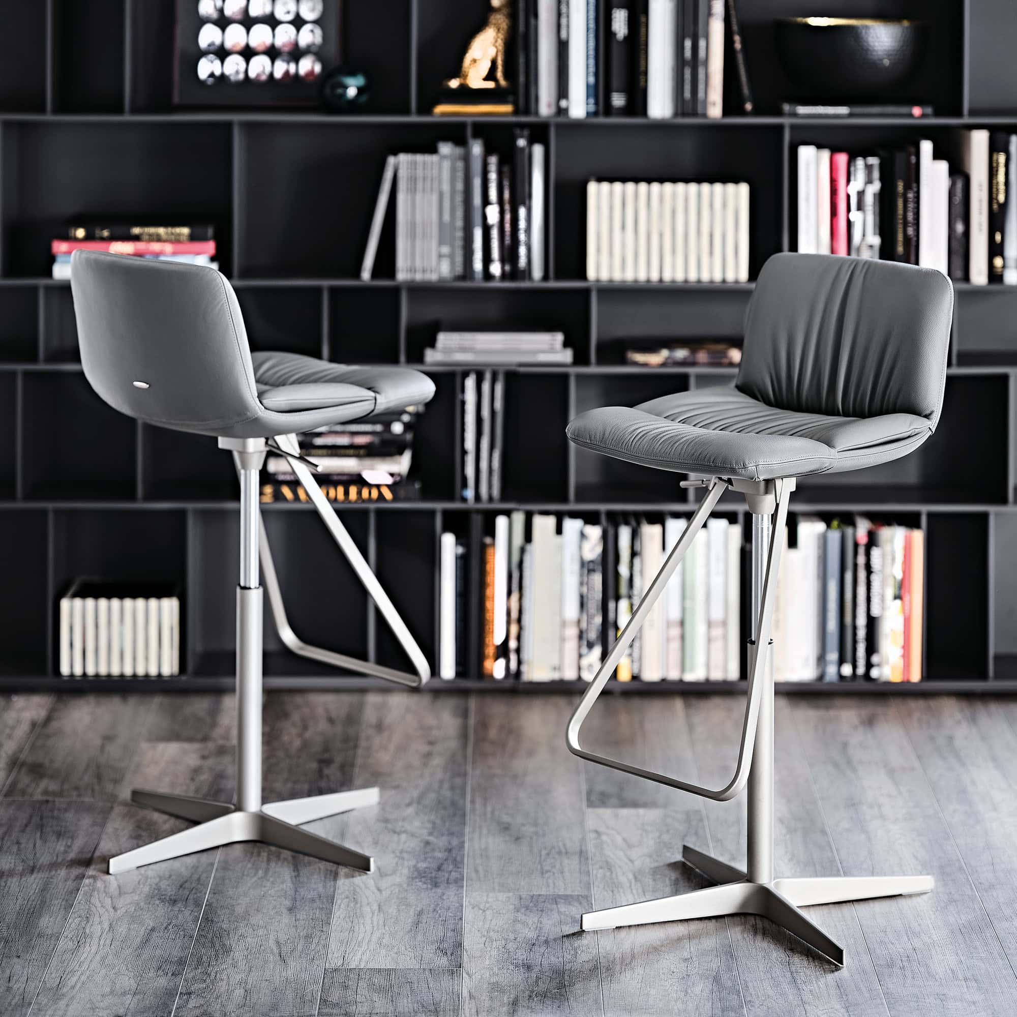Axel X Stool in a contemporary library space with shelves in the background.