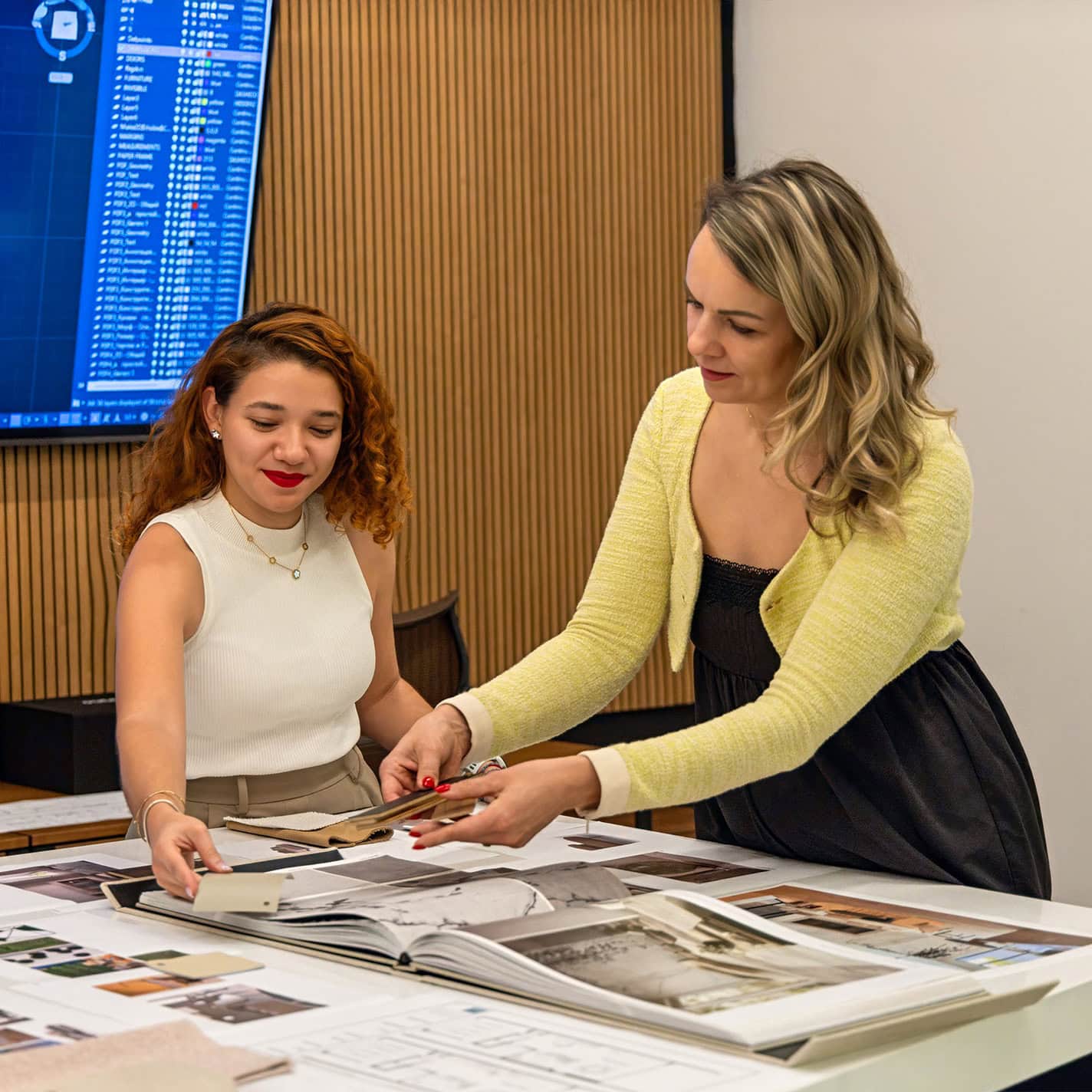 Modern interior design consultation at Sklar Furnishings showroom with two women discussing decor options.