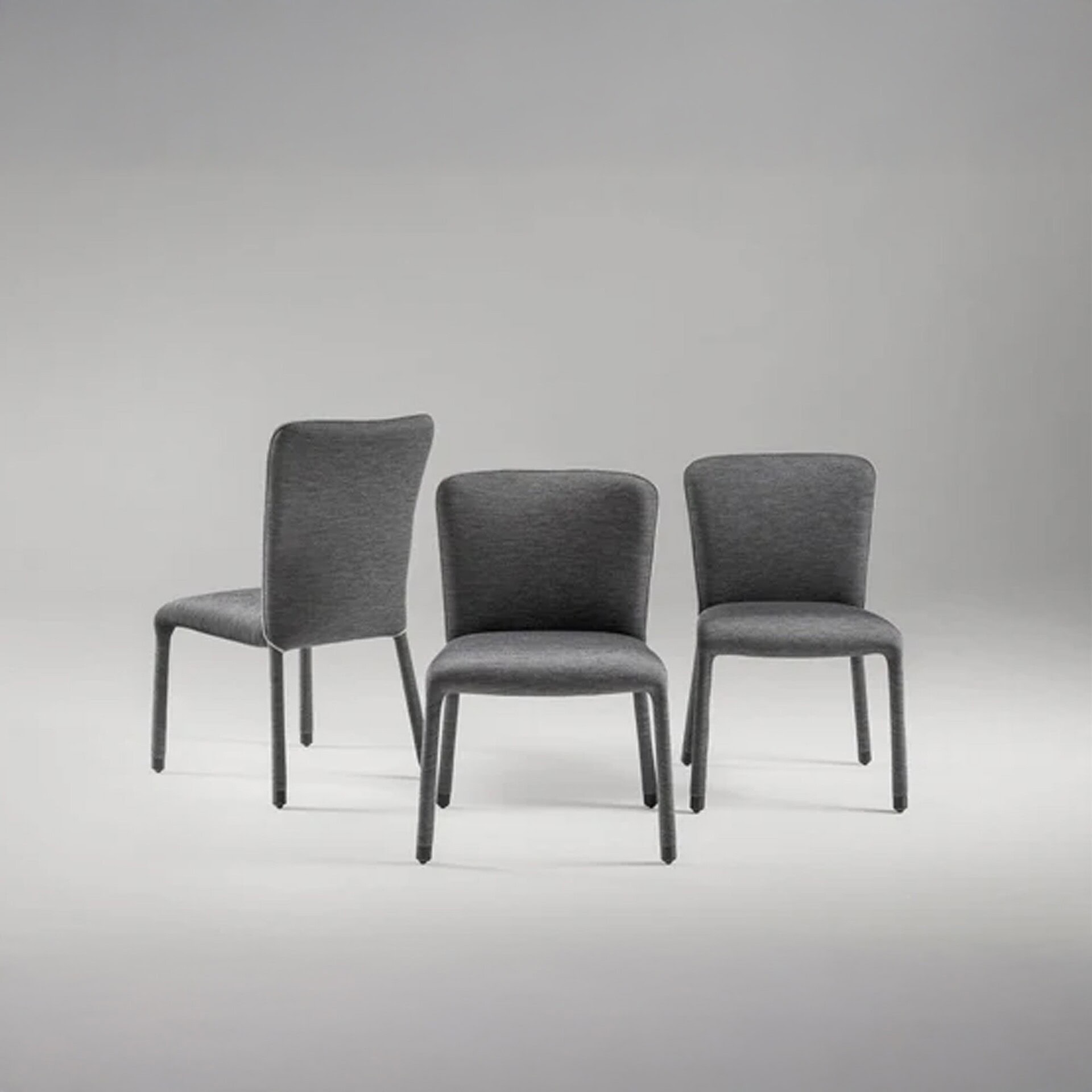 Three S1 Dining Chairs in gray fabric upholstery arranged side by side against a neutral background.